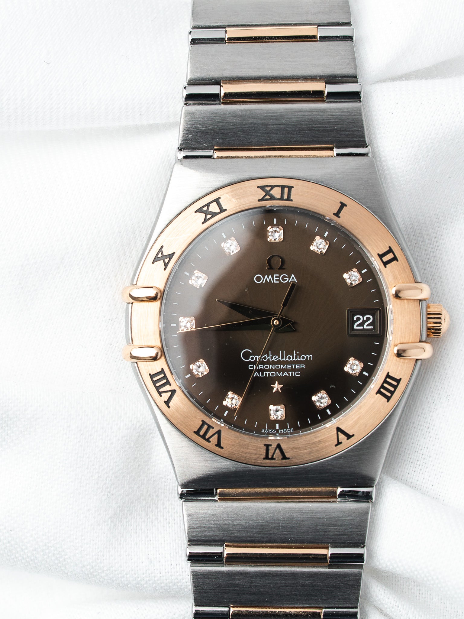 Omega Constellation watch with brown dial, diamond hour markers, and two-tone steel and rose gold bracelet
