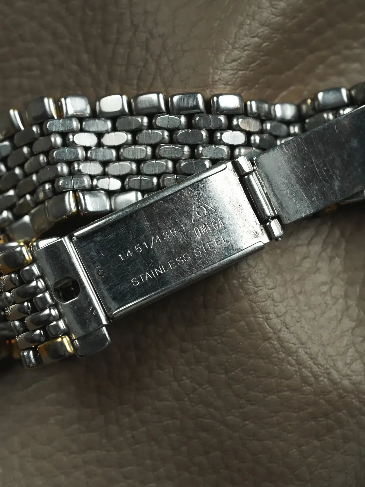 Omega vintage watch bracelet in stainless steel, model 1451/439.1, on textured leather