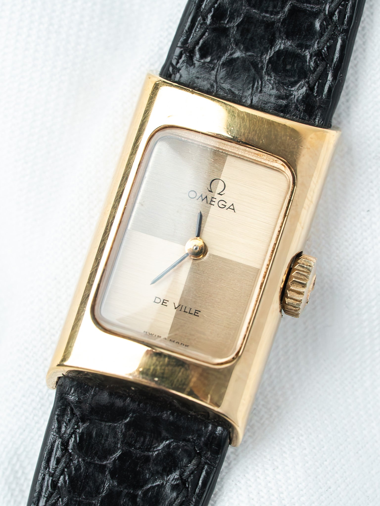 Omega De Ville vintage watch with gold case, two-tone dial, and black alligator strap