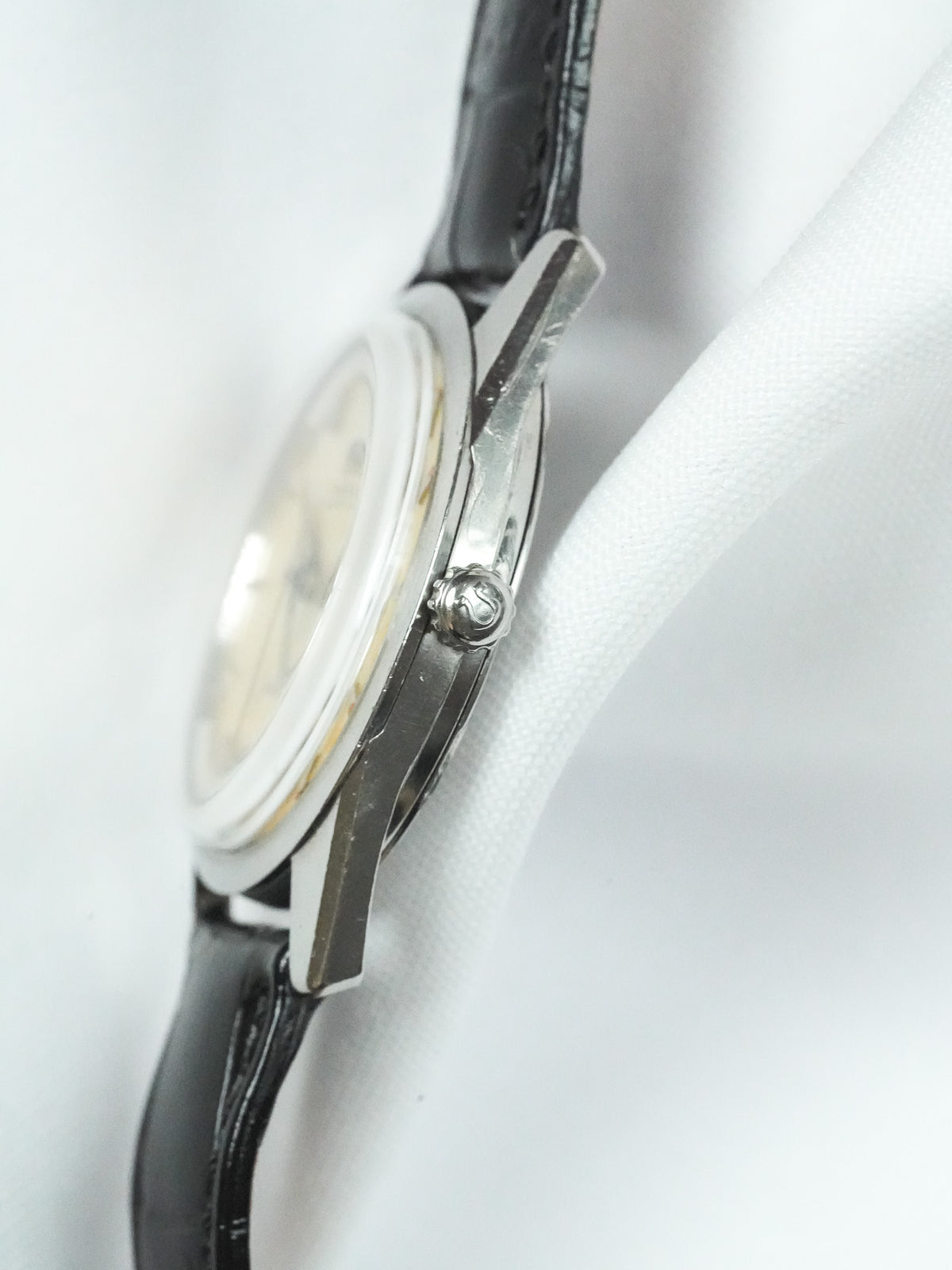 Vintage Omega watch with silver case, cream dial, black leather strap