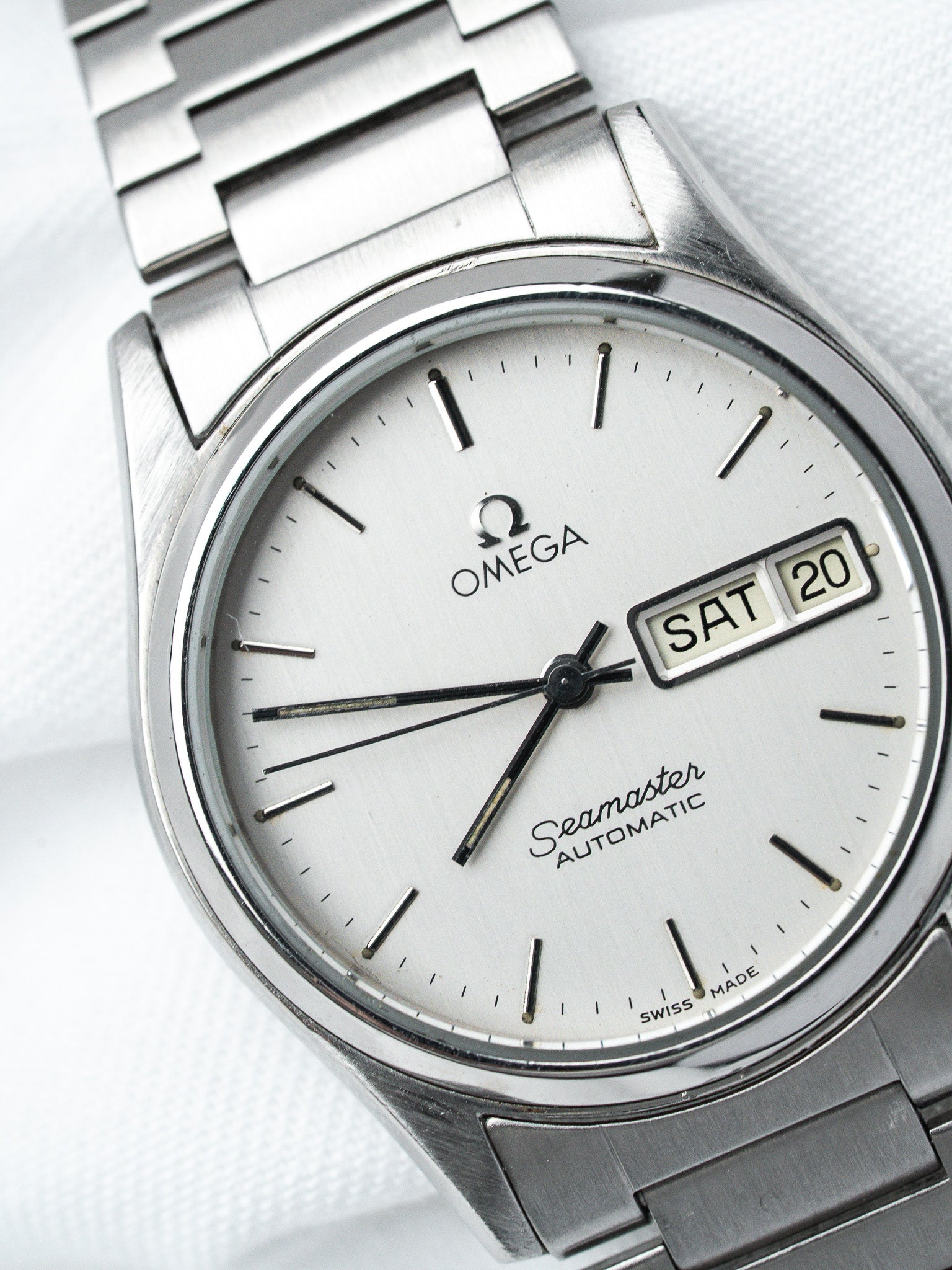 Omega Seamaster vintage automatic watch with silver dial, day-date window, and steel bracelet
