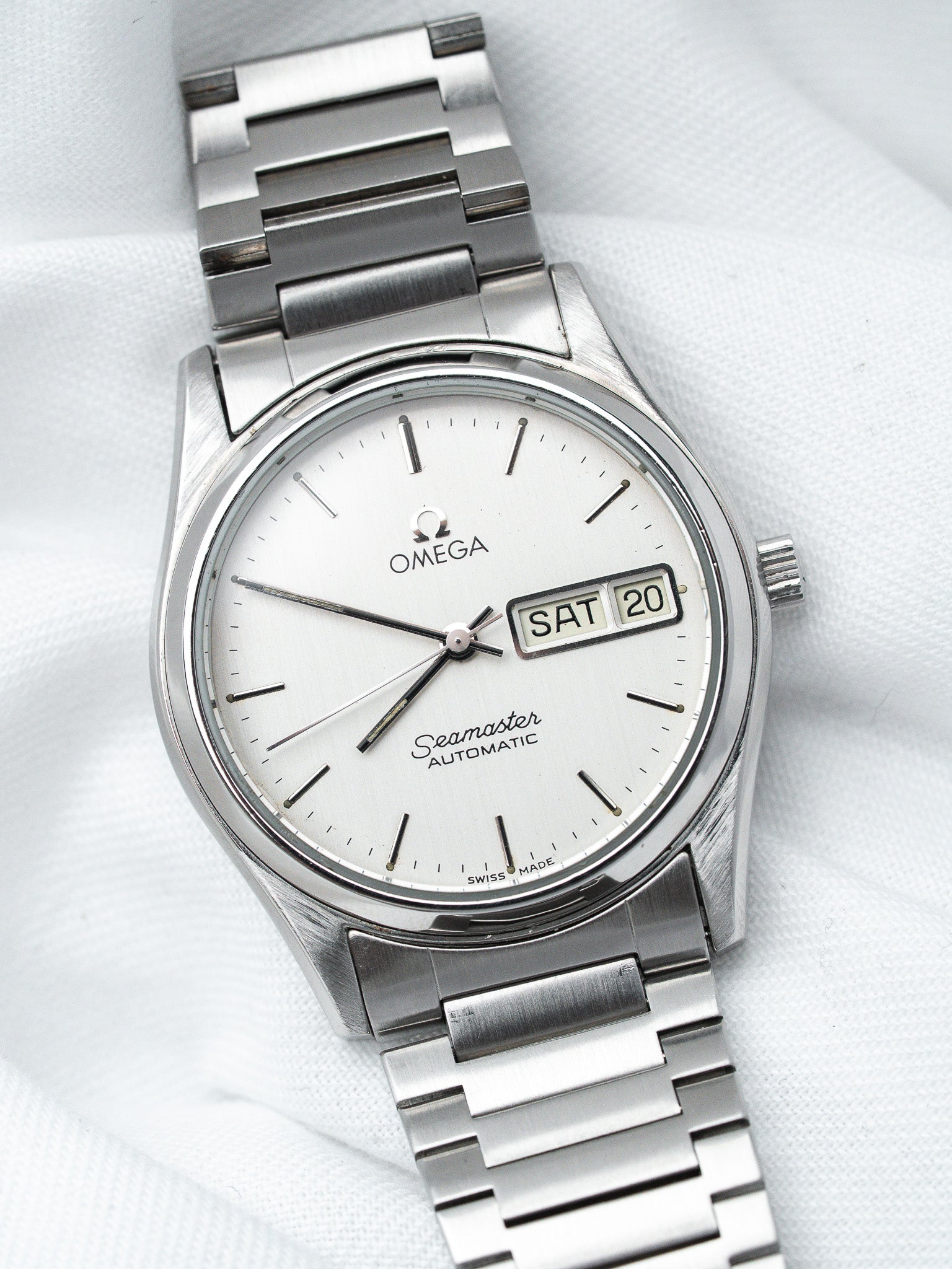 Omega Seamaster vintage automatic watch with silver dial and steel bracelet on white fabric