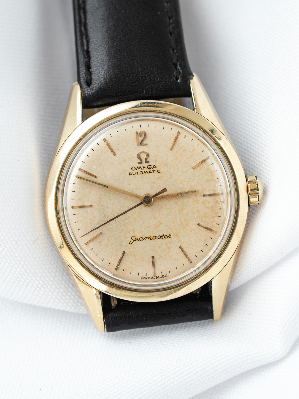 Omega Seamaster vintage watch with gold case, cream dial, and black leather strap