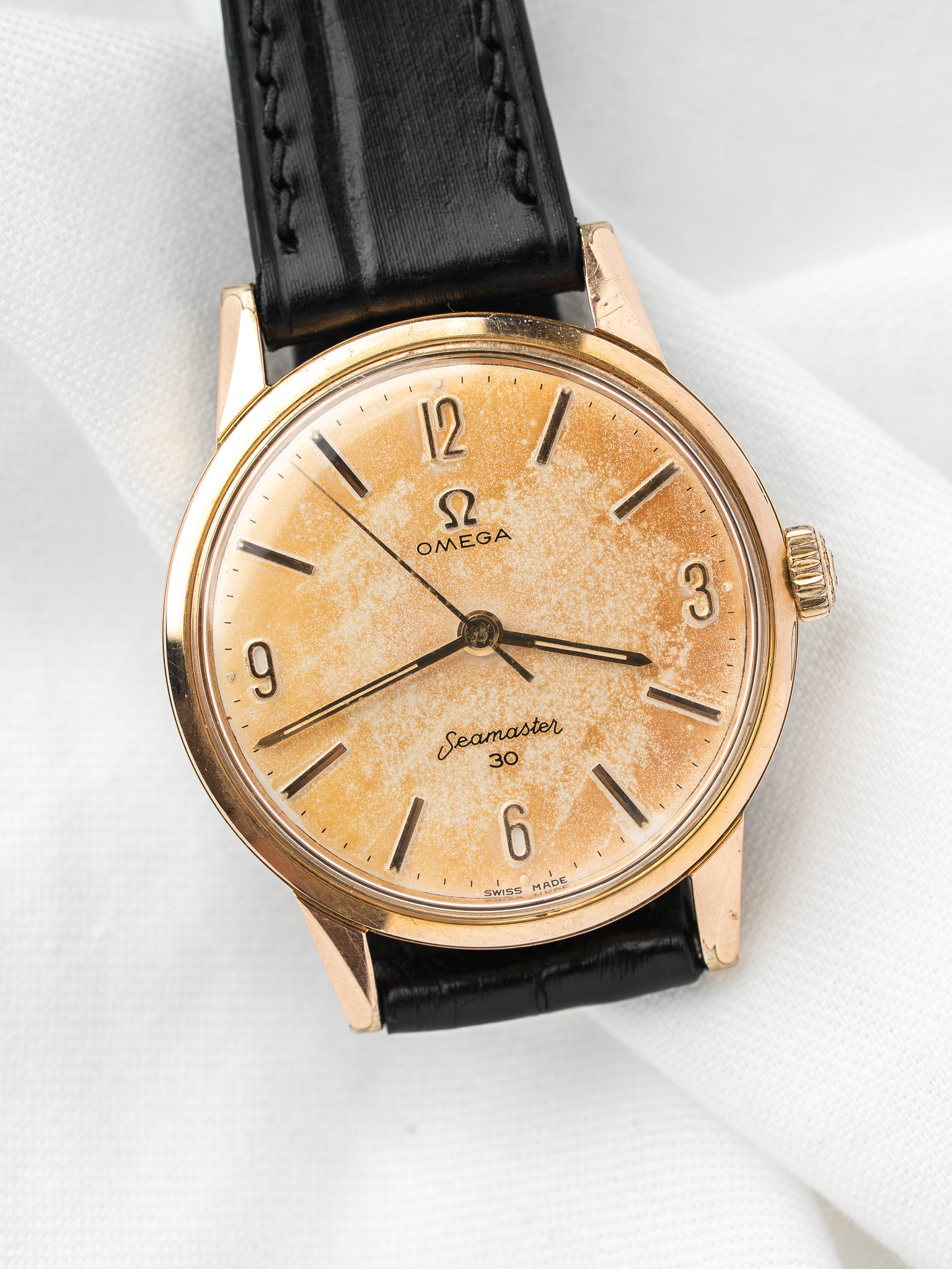 Vintage Omega Seamaster 30 watch with gold case, cream dial, and black leather strap