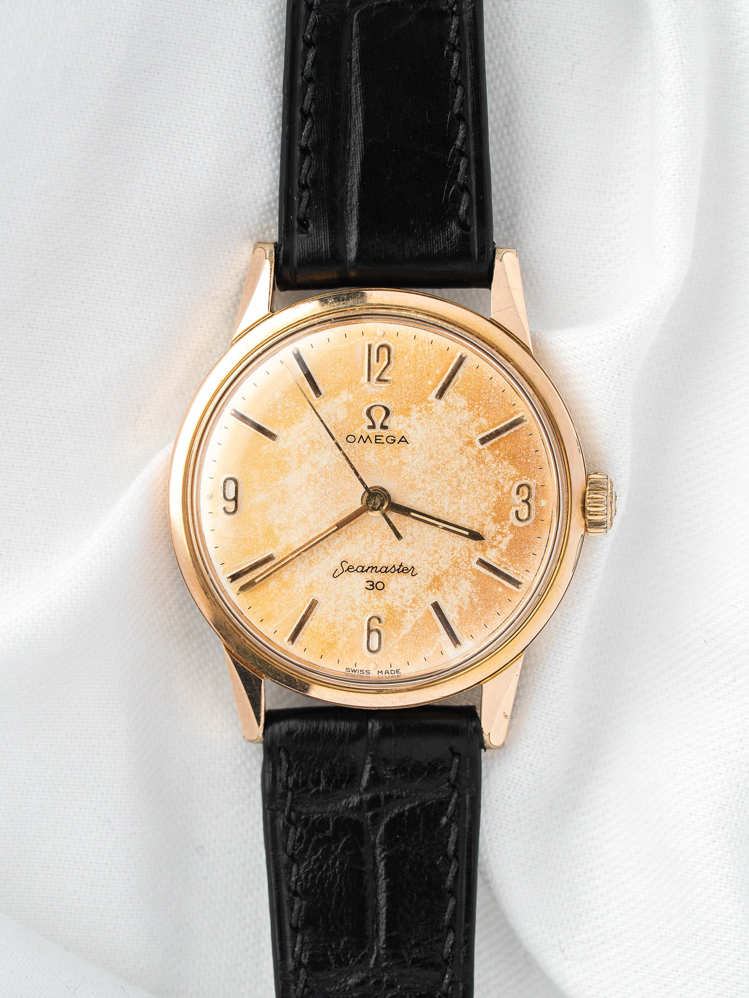 Vintage Omega Seamaster 30 watch with gold case, cream dial, and black leather strap