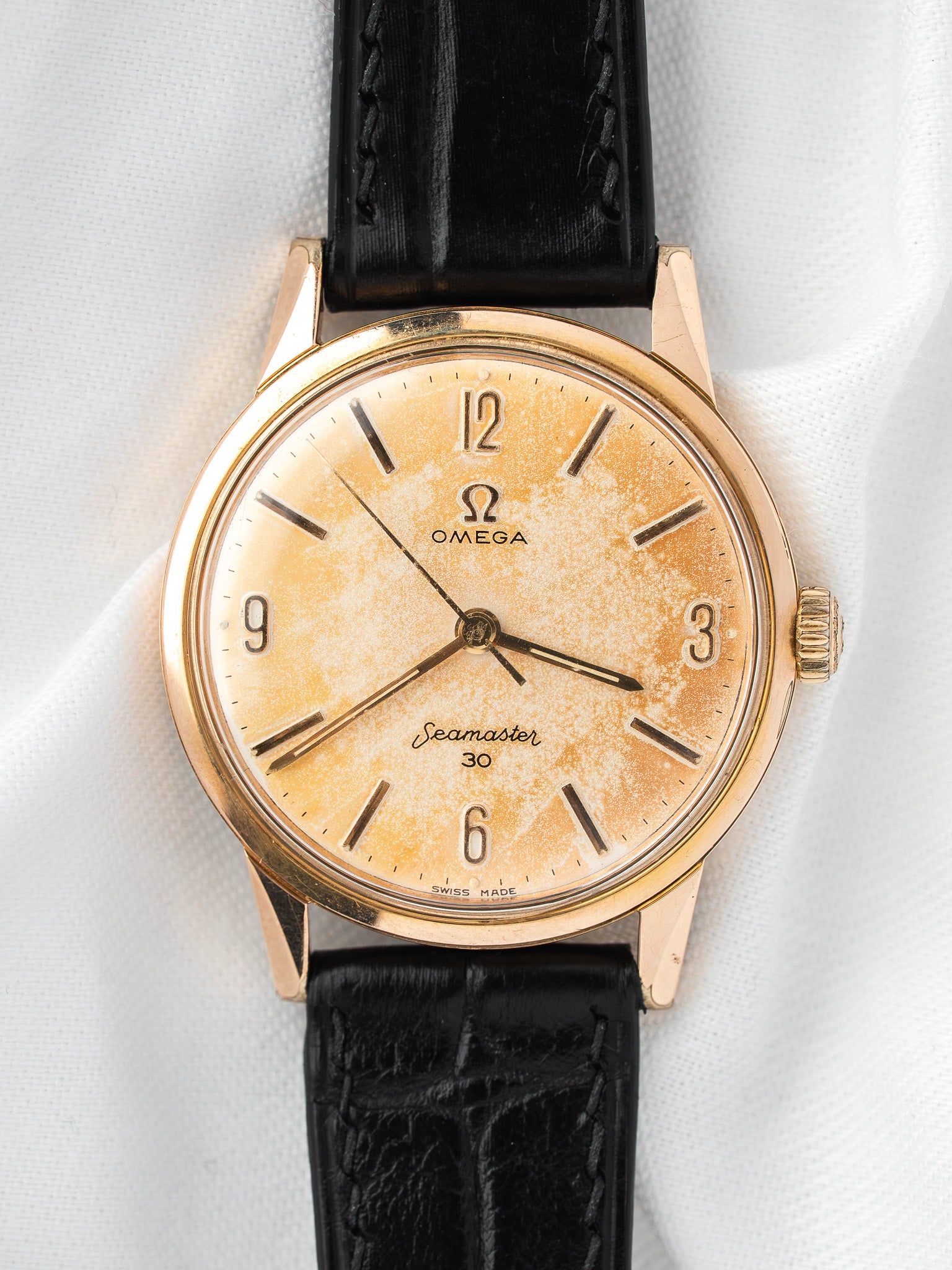 Vintage Omega Seamaster 30 watch with gold case, cream dial, and black leather strap