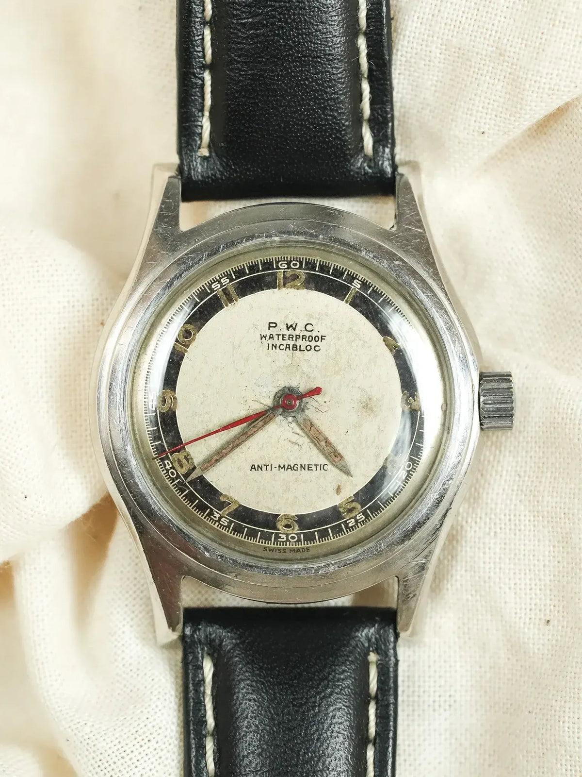 P.W.C. vintage watch with silver case, cream dial, black leather strap