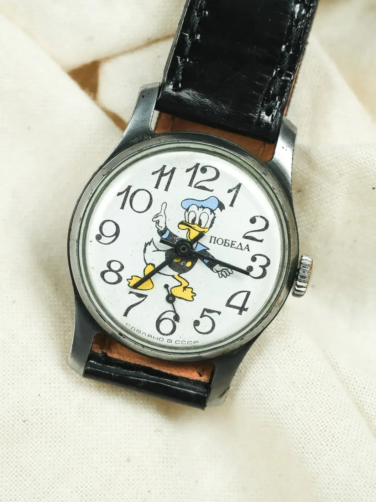 Vintage Pobeda watch with Donald Duck dial, black leather strap, white face