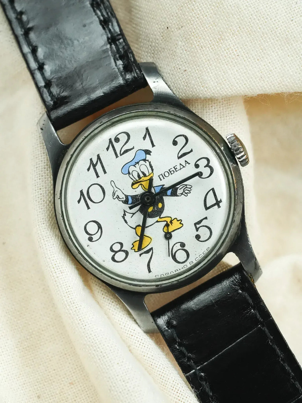 Vintage Pobeda watch with Donald Duck dial, black leather strap, white face