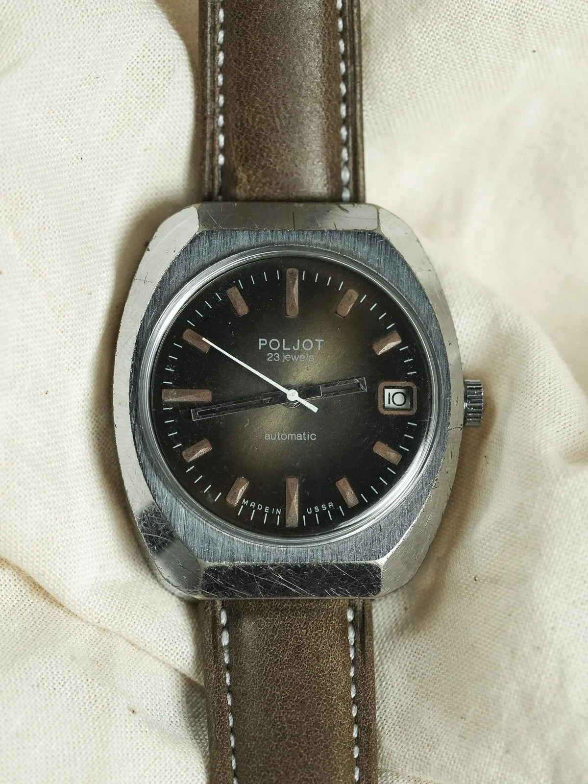 Vintage Poljot automatic watch with black dial, steel case, brown leather strap on fabric