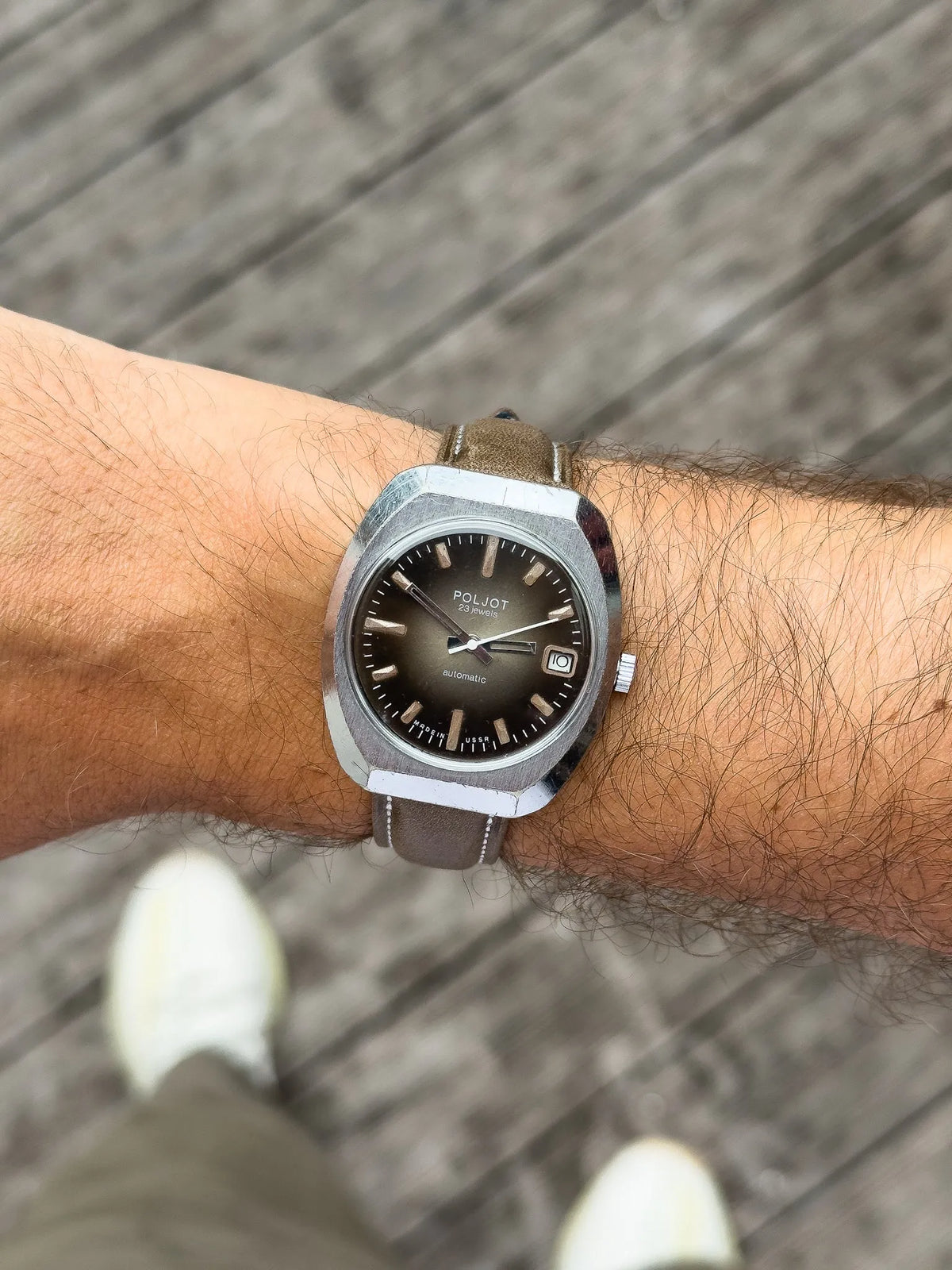 Poljot vintage automatic watch with brown dial, steel case, and leather strap on wrist