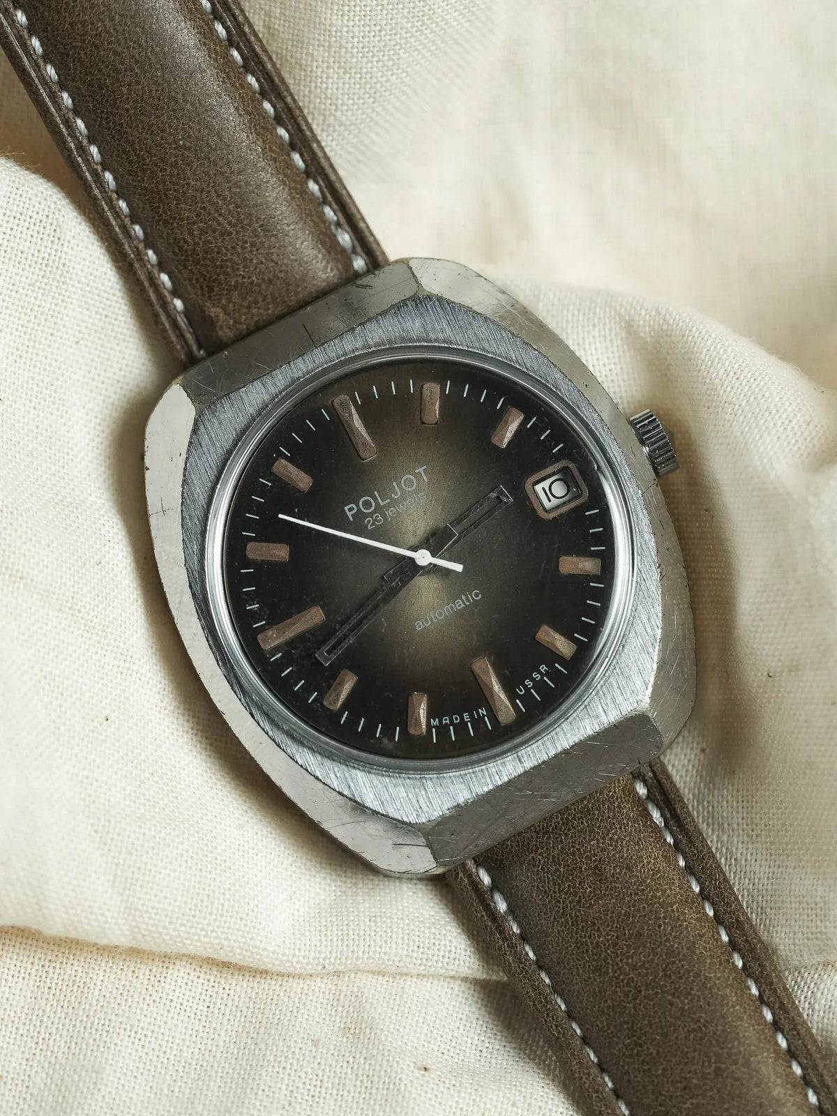 Poljot vintage automatic watch with black dial, steel case, brown leather strap on fabric