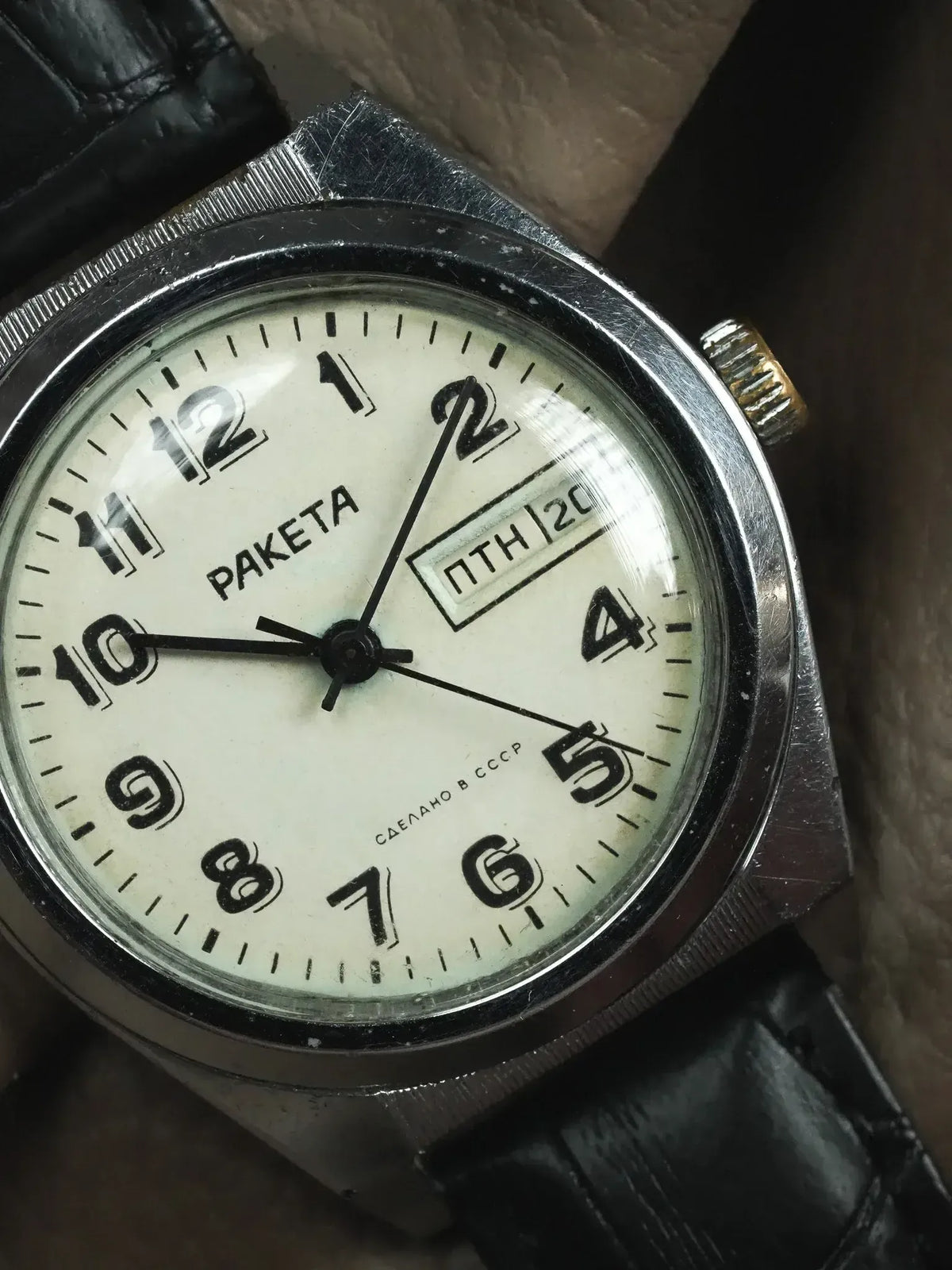Raketa vintage watch with white dial, black numerals, and black leather strap