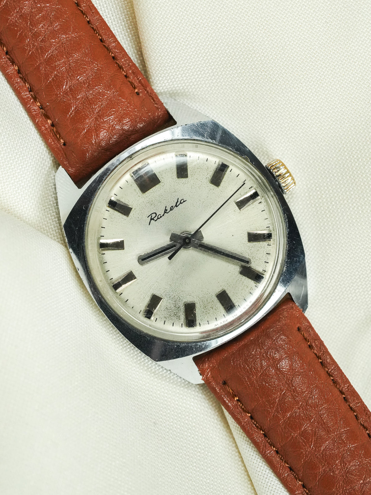 Raketa vintage watch with silver dial, brown leather strap, and steel case