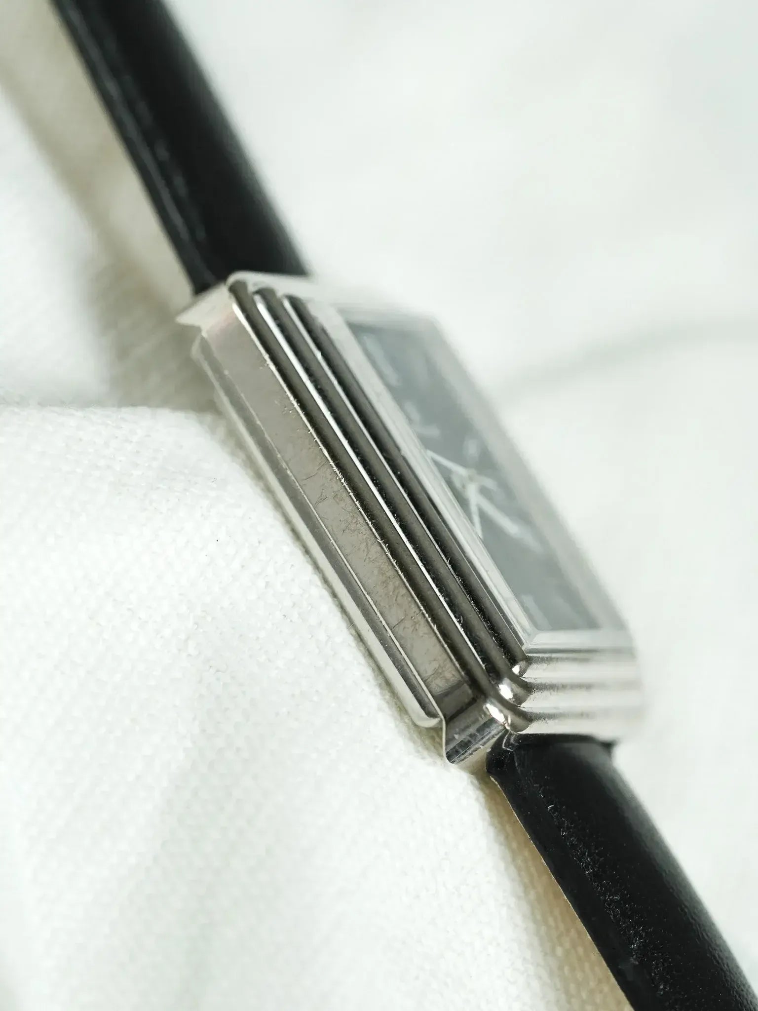 Vintage Cartier Tank watch with rectangular silver case and black leather strap