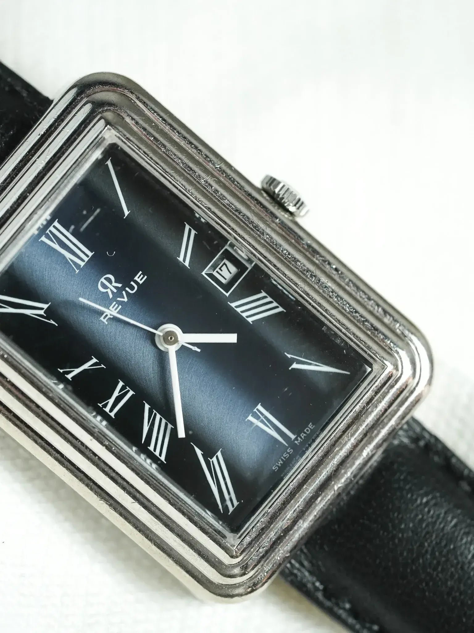 Revue vintage watch with black dial, Roman numerals, and black leather strap