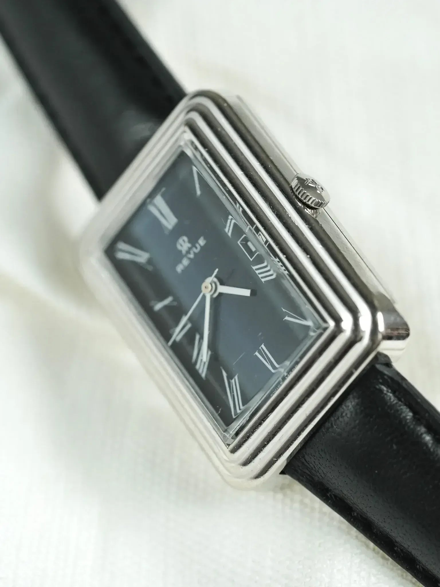 Revue vintage watch with rectangular case, black dial, Roman numerals, and black leather strap