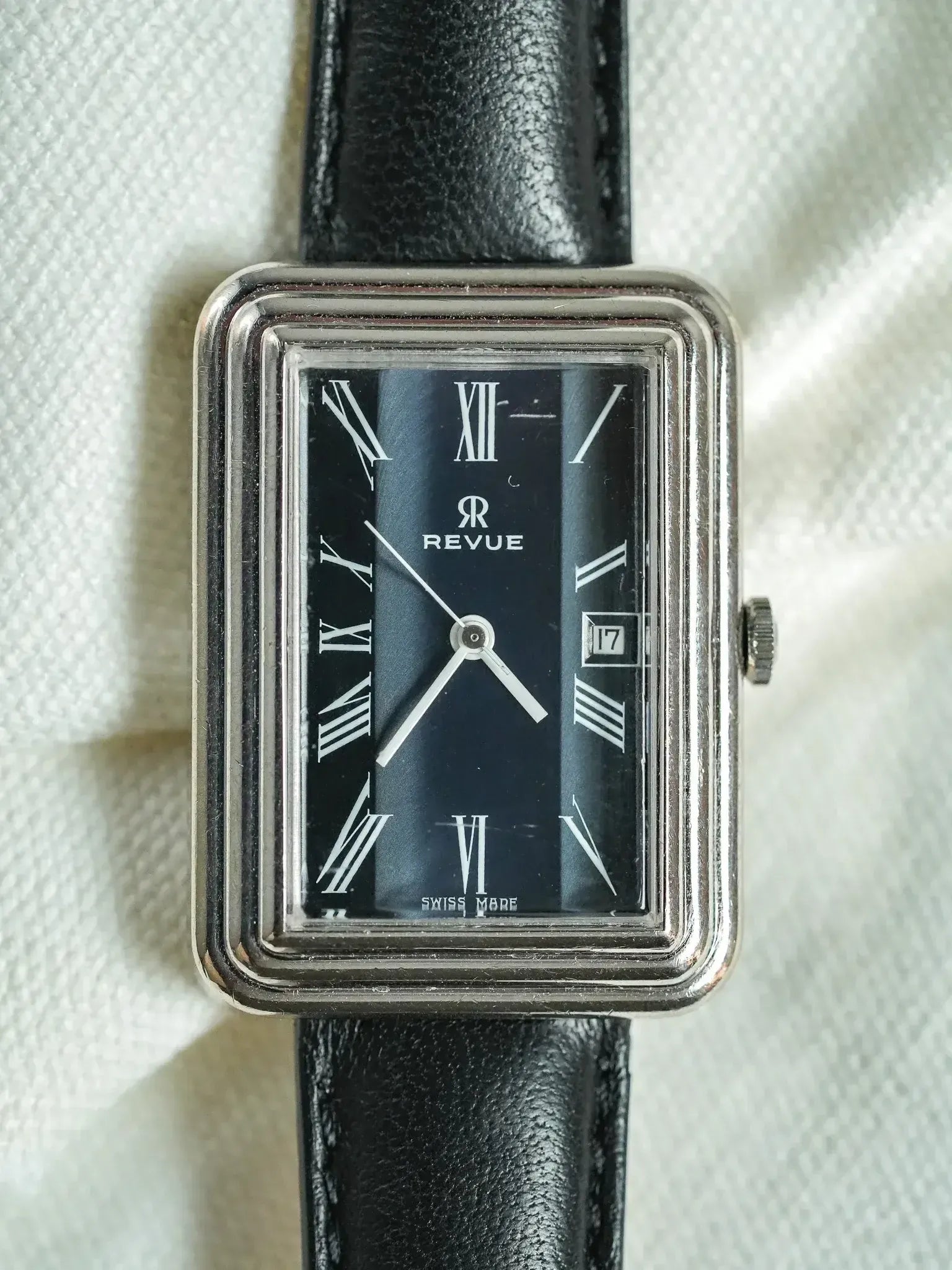 Revue vintage rectangular watch with black dial, Roman numerals, and black leather strap