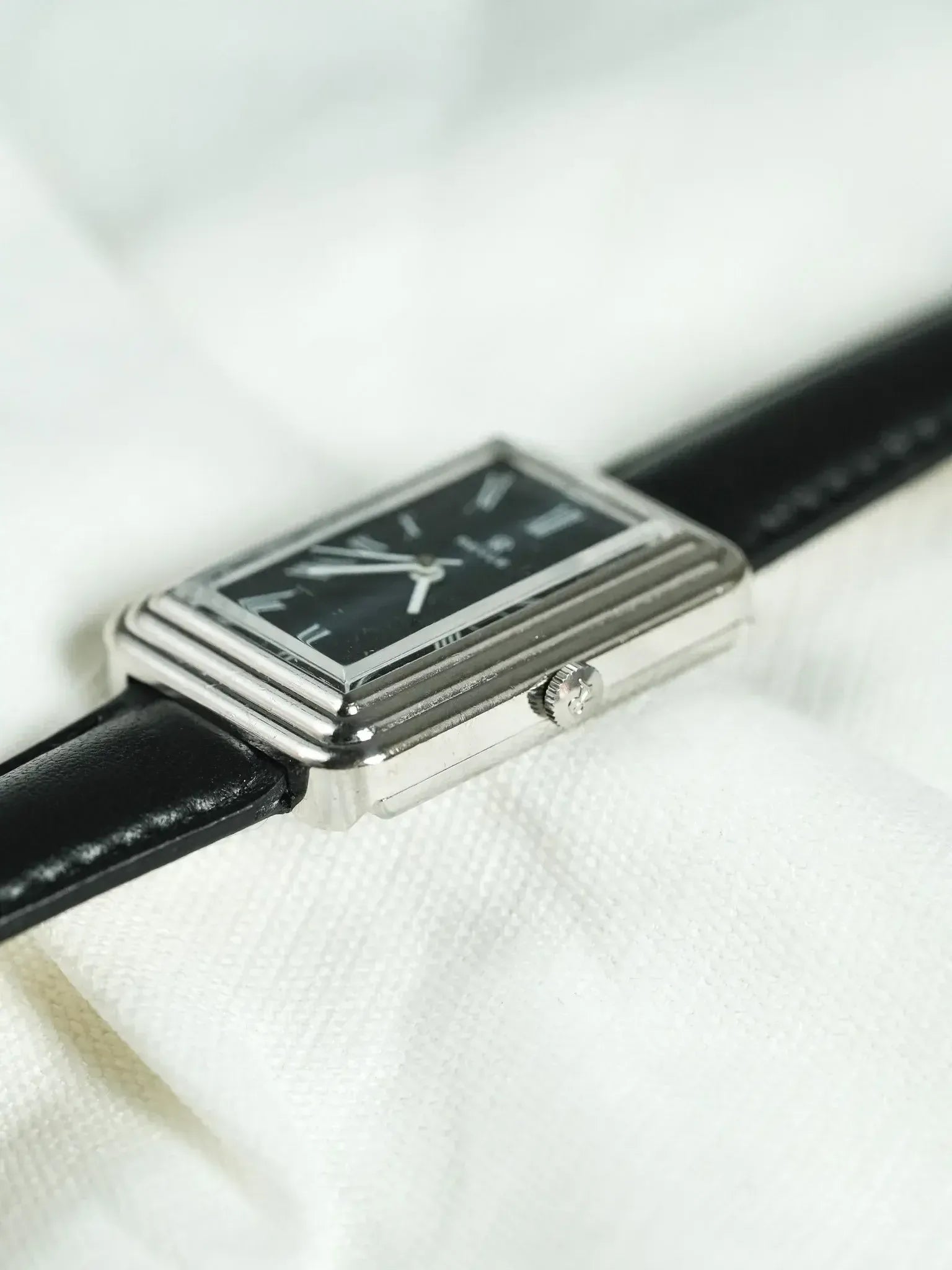 Cartier Tank vintage watch with black dial, silver case, and black leather strap