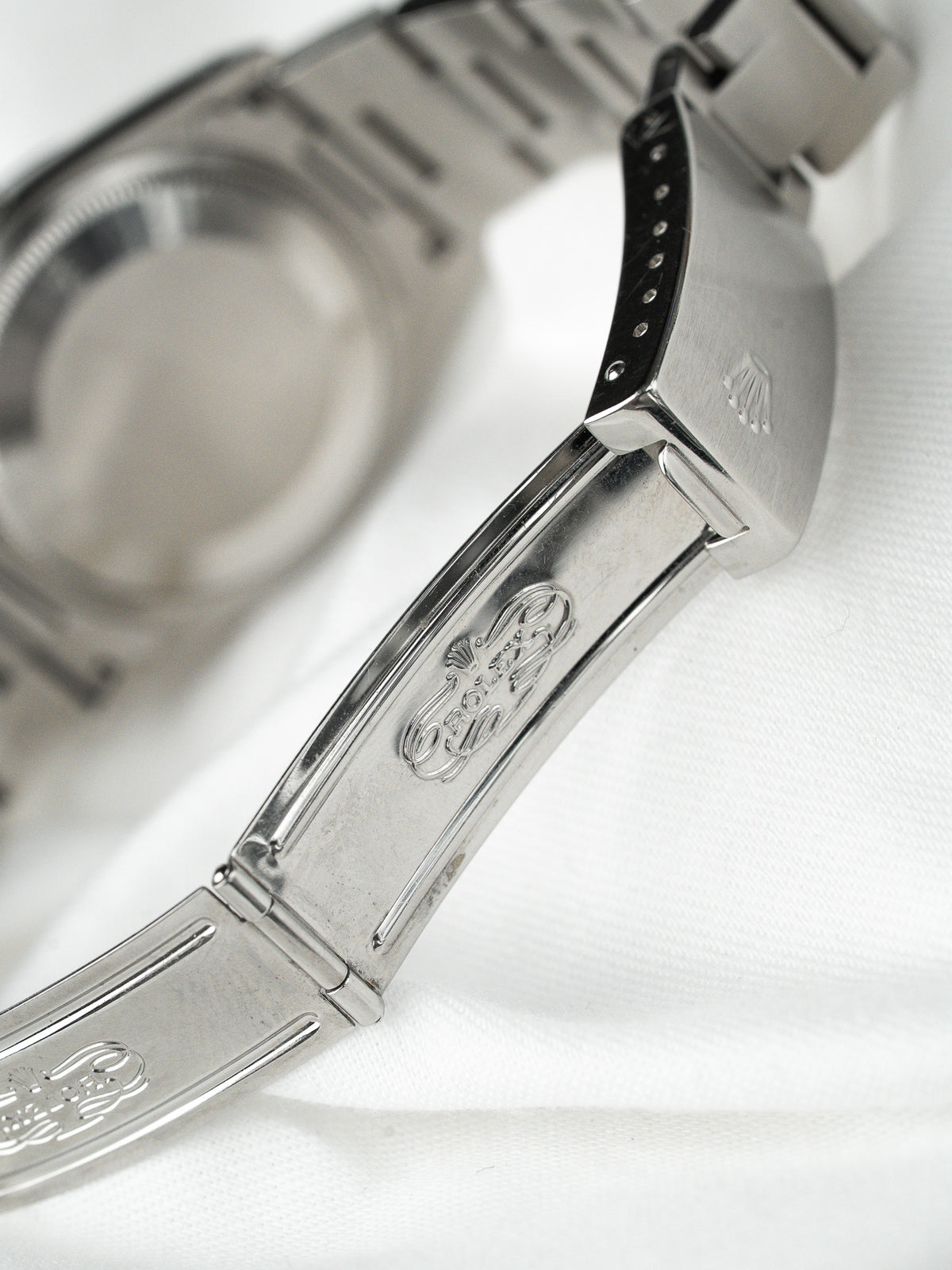 Fermoir et bracelet en acier d'une montre Rolex vintage sur fond blanc