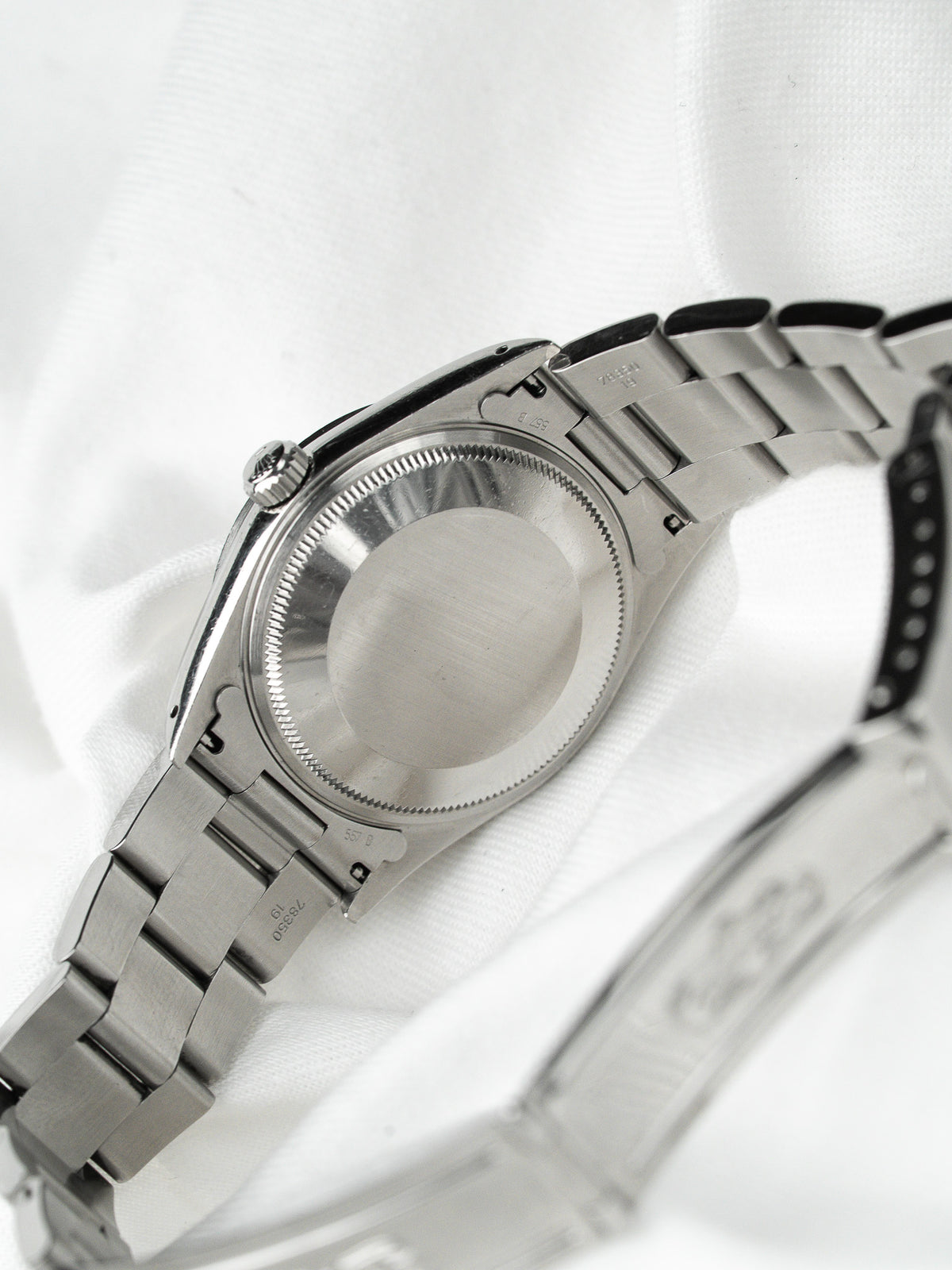 Vue arrière d'une montre Rolex en acier avec bracelet Oyster sur fond blanc