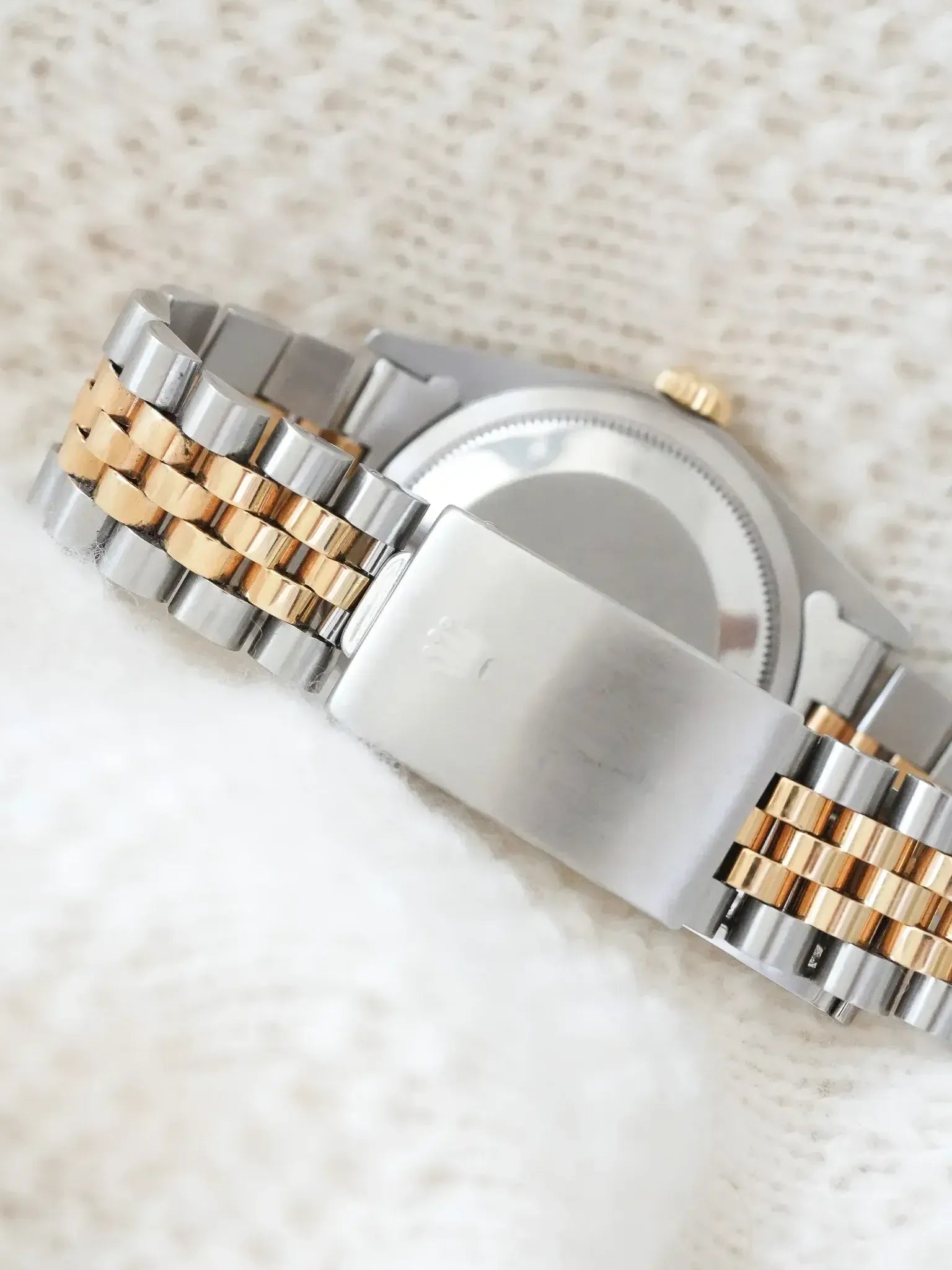 Rolex vintage watch with two-tone steel and gold bracelet on textured white background