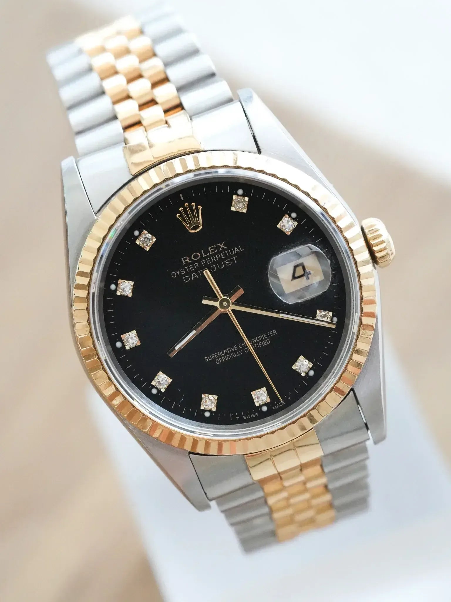 Rolex Datejust vintage with black dial, diamond hour markers, and two-tone bracelet