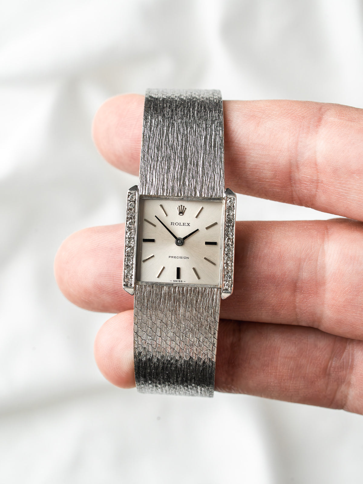 Montre Rolex vintage rectangulaire en acier avec cadran argenté et bracelet texturé