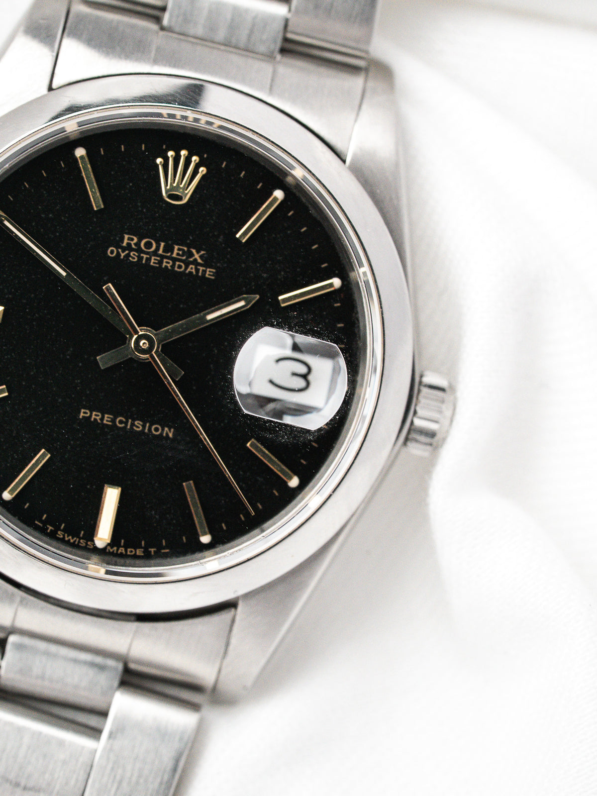 Montre Rolex Oysterdate vintage en acier, cadran noir et bracelet métallique