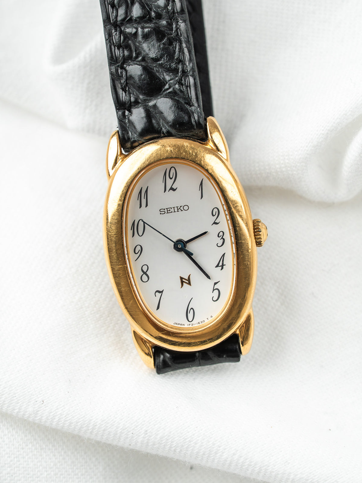 Montre Seiko vintage, boîtier ovale plaqué or, cadran blanc et bracelet cuir noir