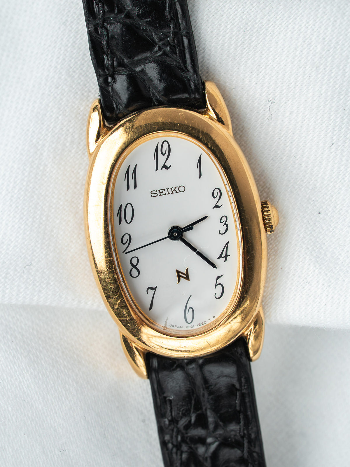 Montre Seiko vintage, boîtier ovale plaqué or, cadran blanc et bracelet cuir noir