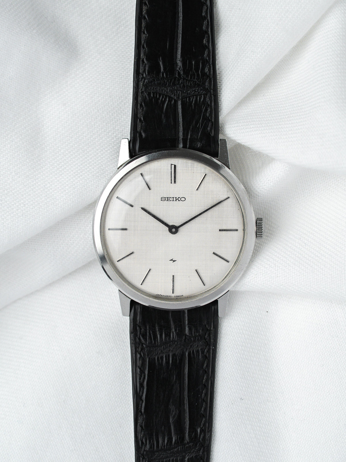 Seiko vintage watch with white dial, black leather strap, and silver case