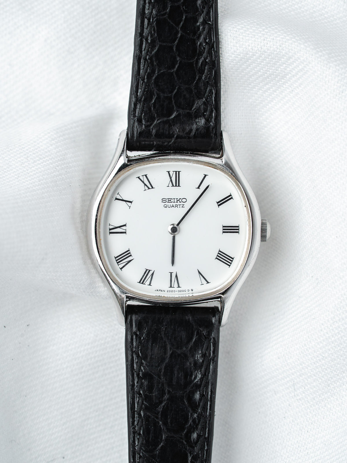 Seiko Quartz vintage watch with white dial, Roman numerals, black textured strap