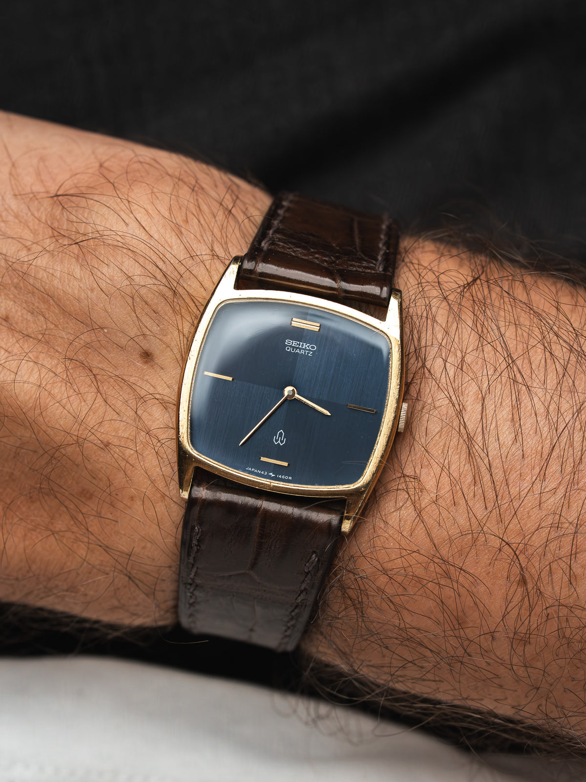 Montre Seiko Quartz vintage au cadran bleu et bracelet en cuir marron.