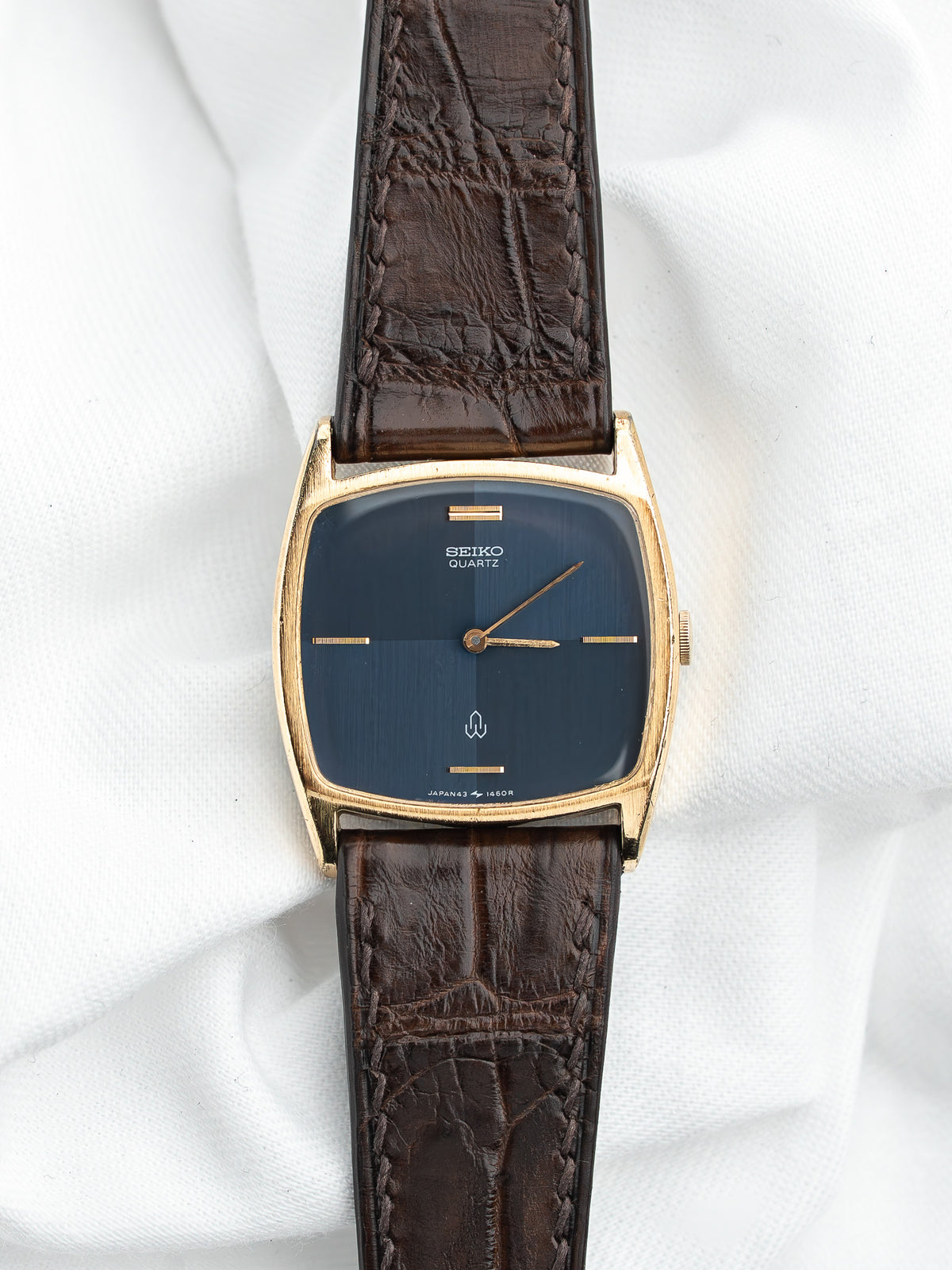 Montre Seiko Quartz vintage au cadran bleu et bracelet en cuir marron.