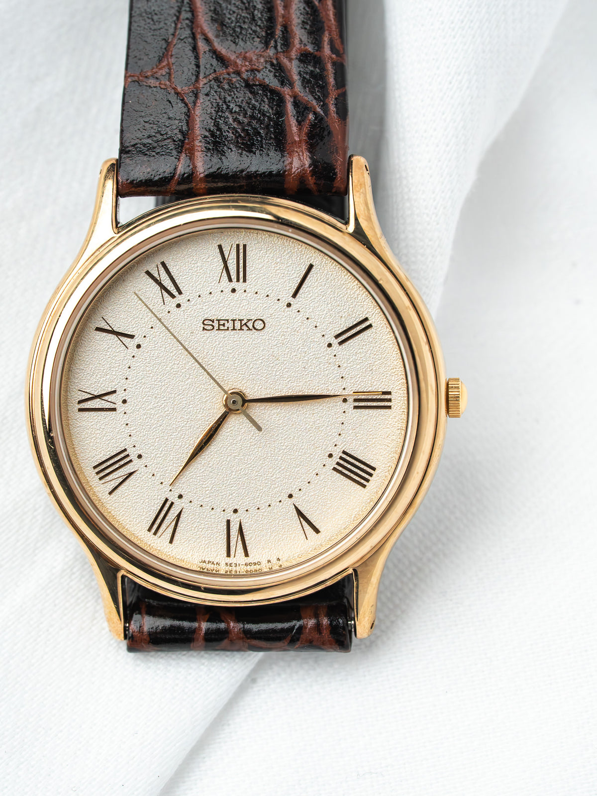Seiko vintage watch with gold case, cream dial, Roman numerals, brown alligator strap