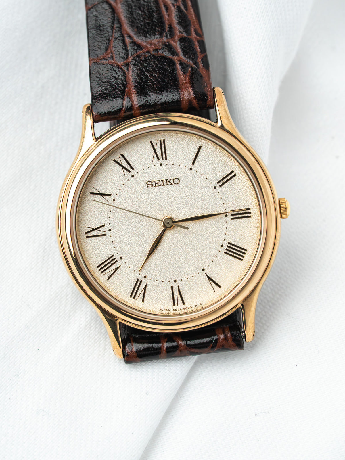 Seiko vintage watch with gold case, cream dial, Roman numerals, brown alligator strap