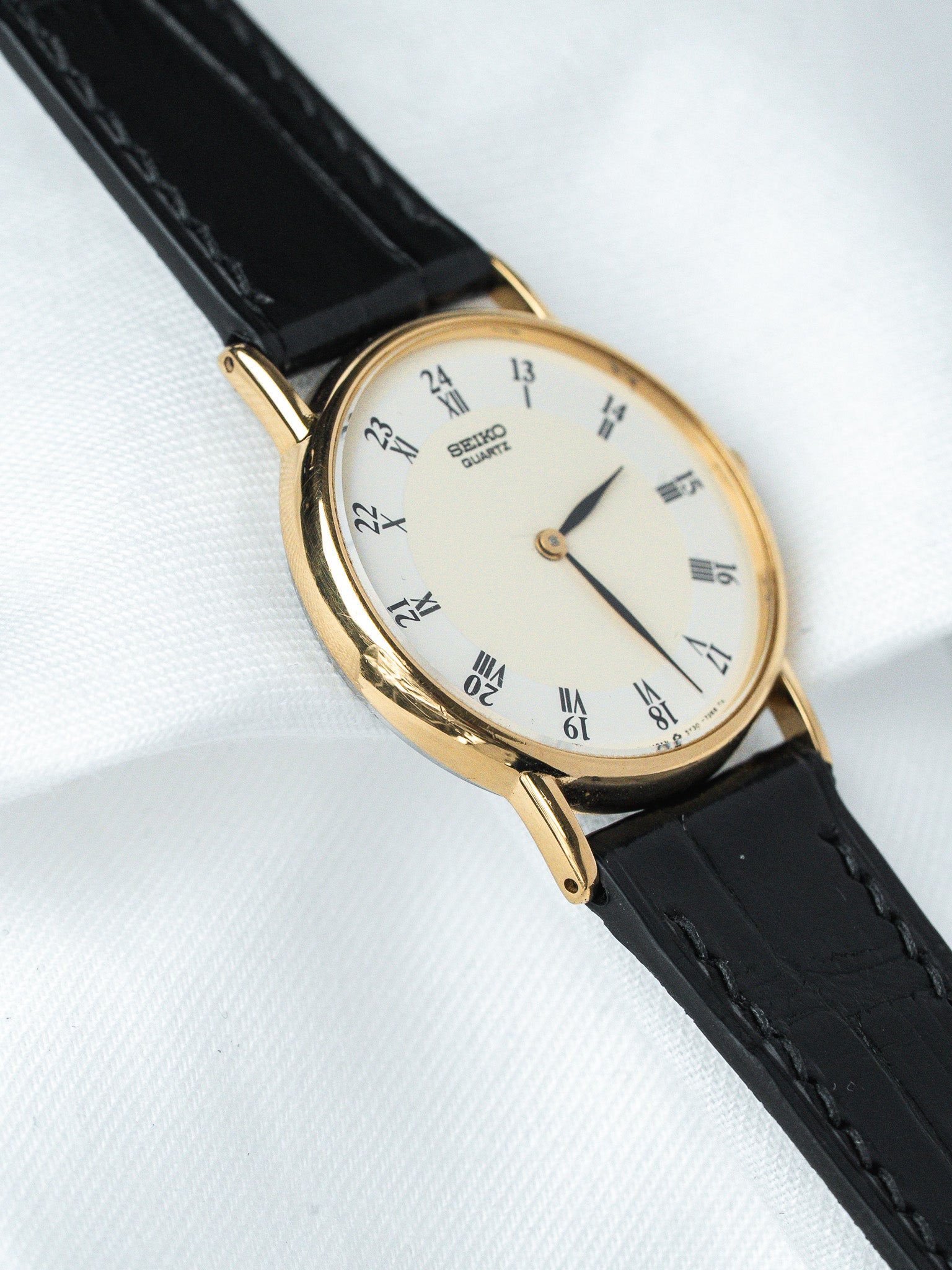 Seiko Quartz vintage watch with gold case, white dial, black leather strap
