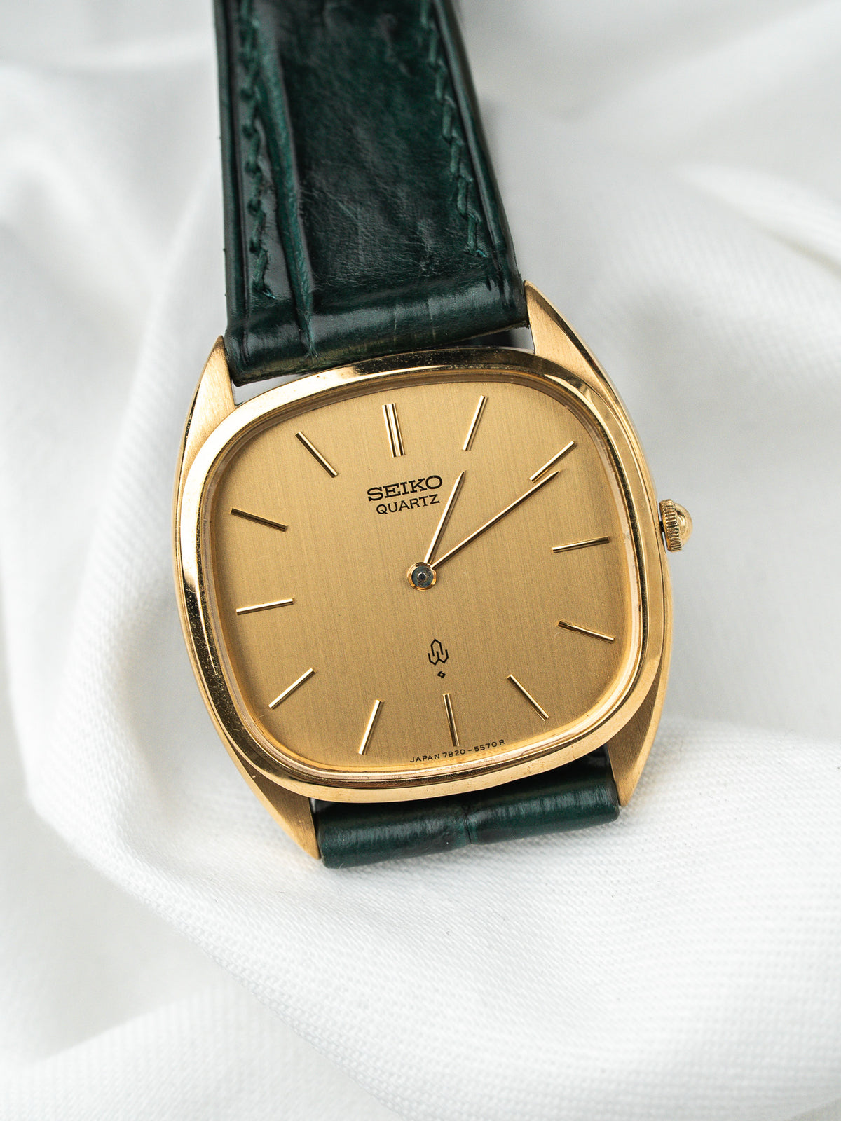 Montre Seiko Quartz vintage, boîtier rectangulaire doré, cadran champagne et bracelet cuir vert