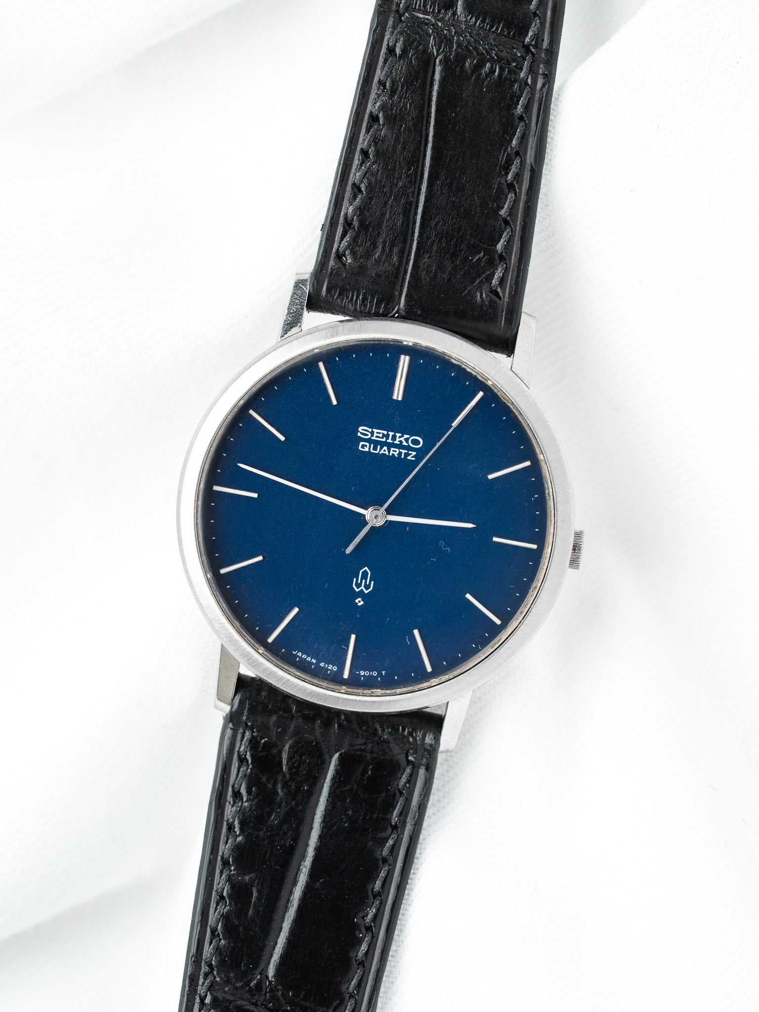 Seiko Quartz vintage watch with blue dial, silver case, black leather strap on white background
