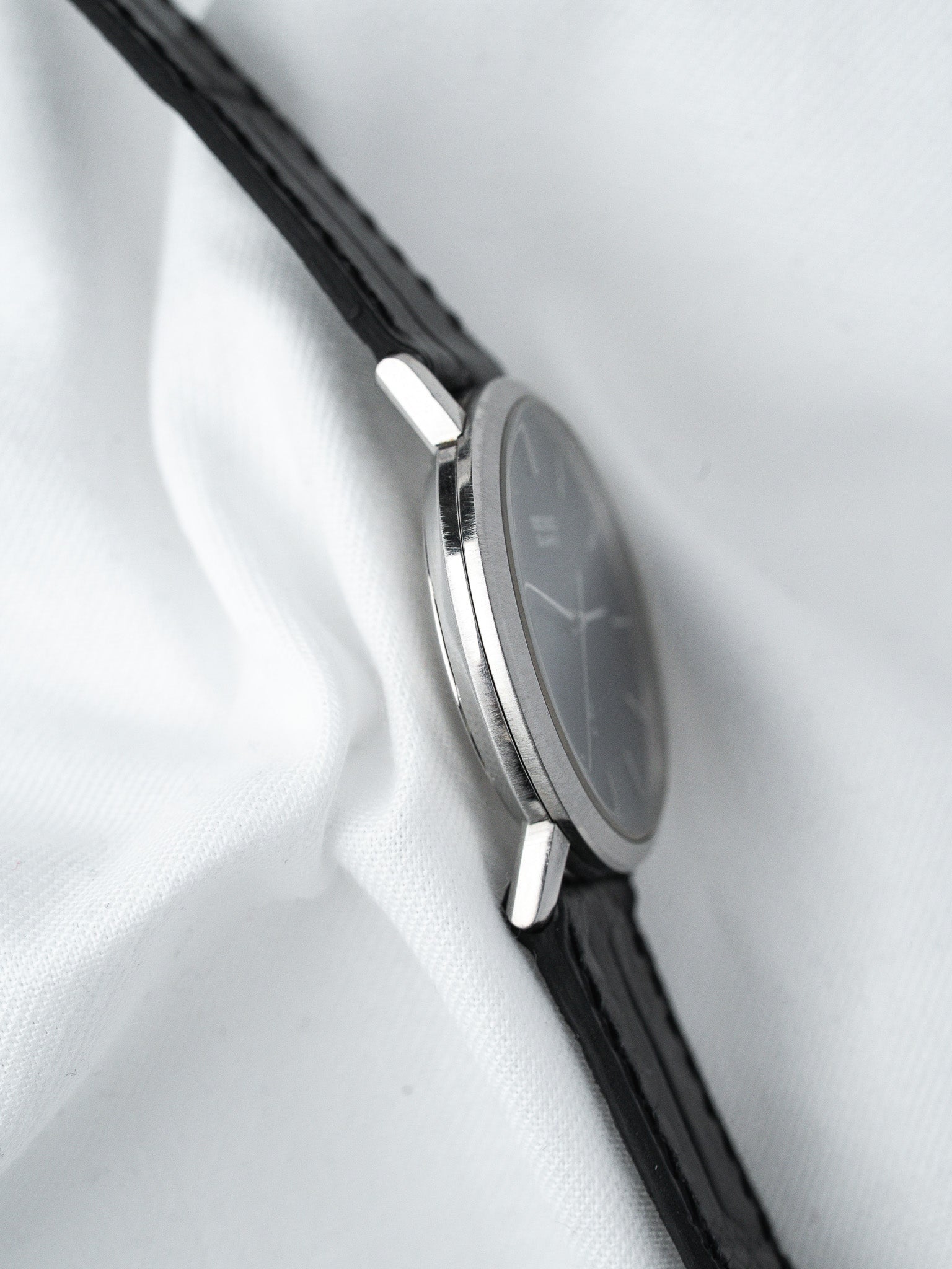 Montre vintage en acier avec cadran gris et bracelet cuir noir