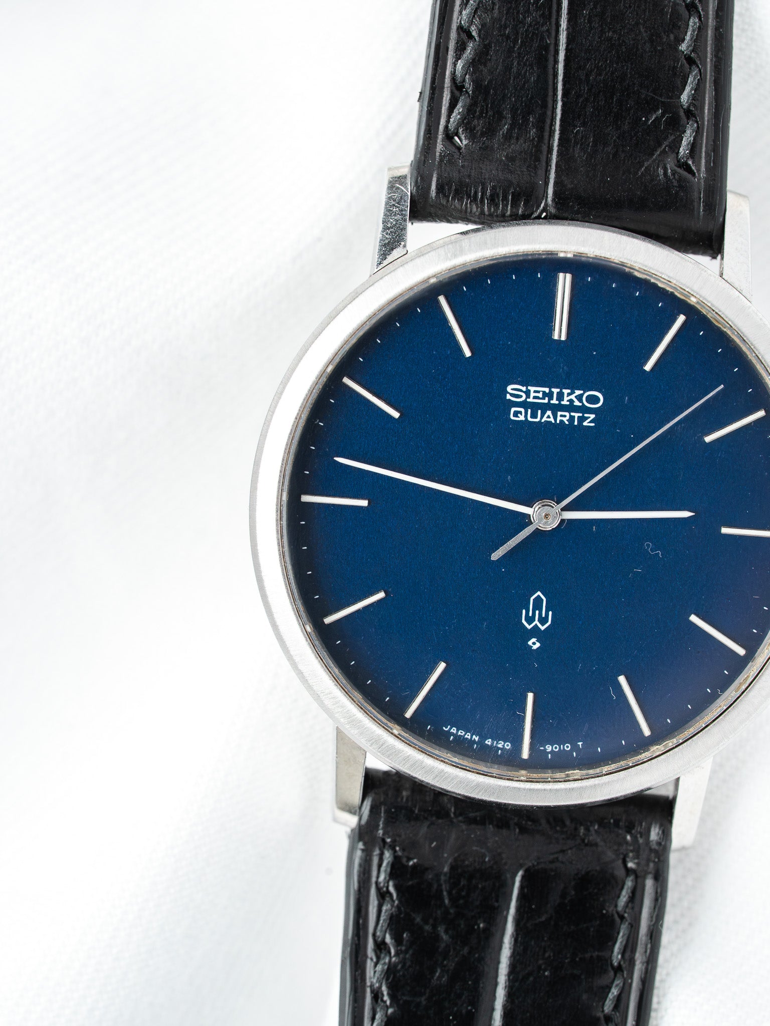 Seiko Quartz vintage watch with blue dial, silver markers, black leather strap on white background