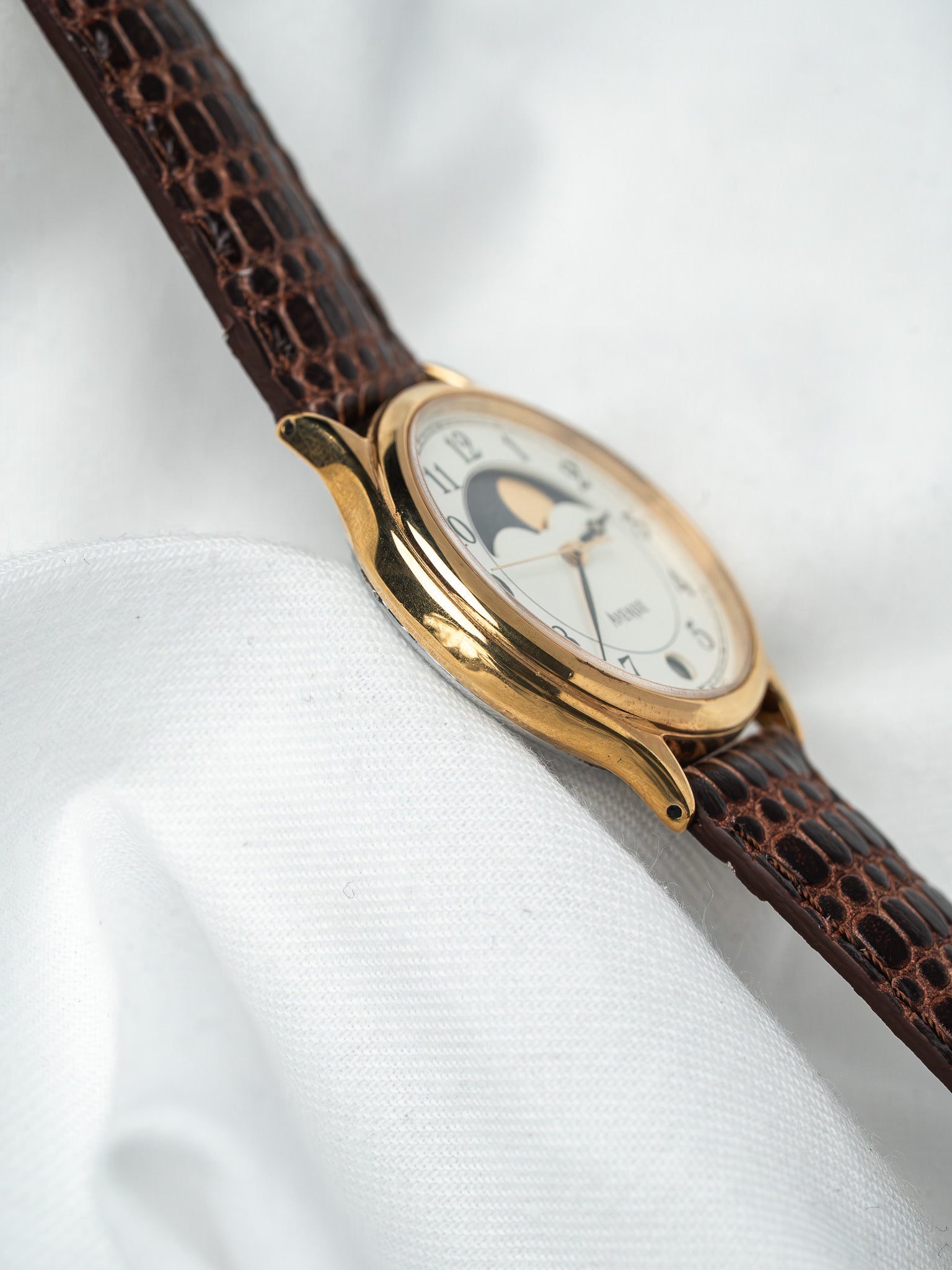Montre vintage Universal Genève en or, cadran blanc avec phase de lune, bracelet cuir marron