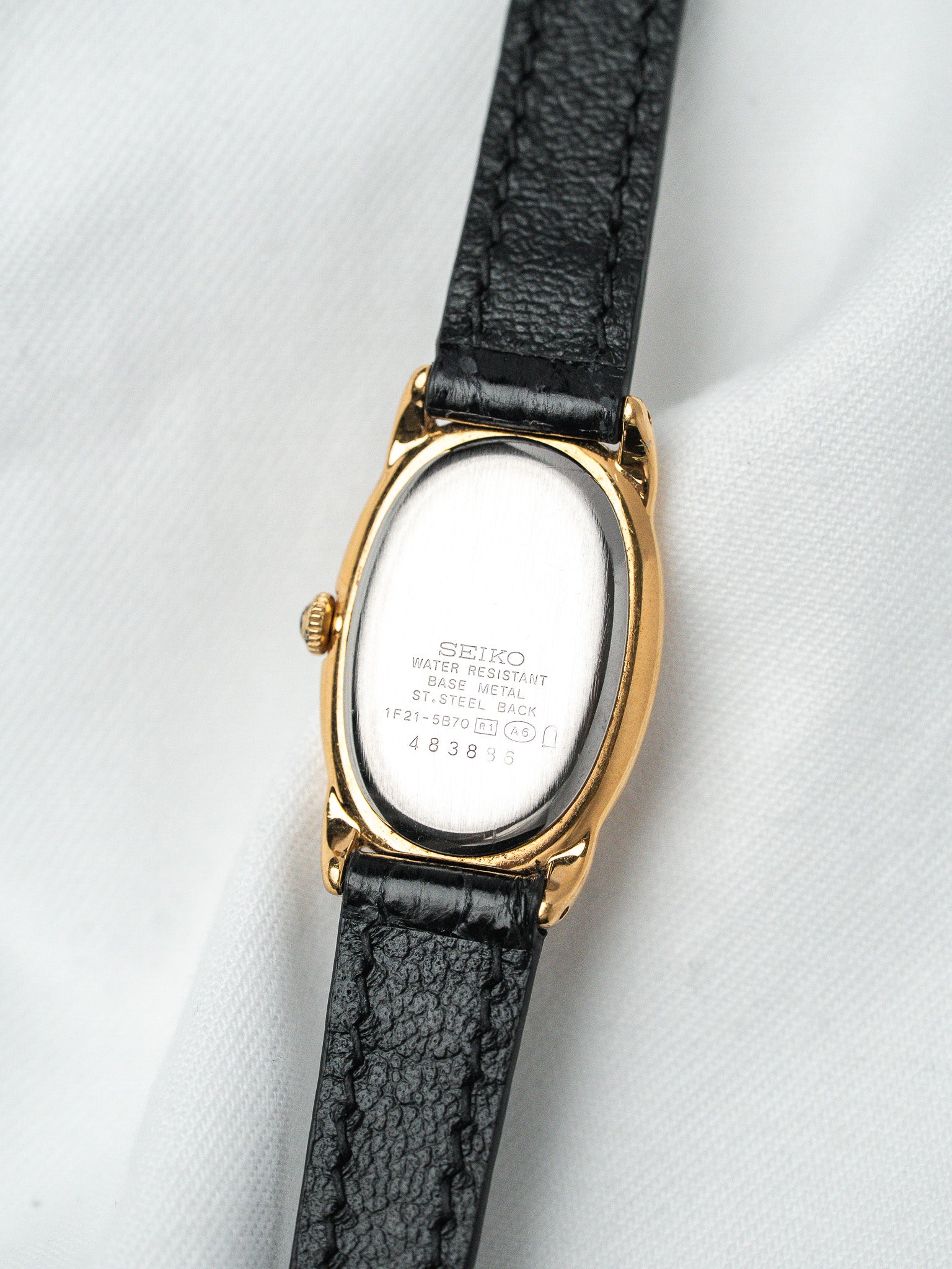 Seiko vintage watch with gold case, black leather strap, stainless steel back