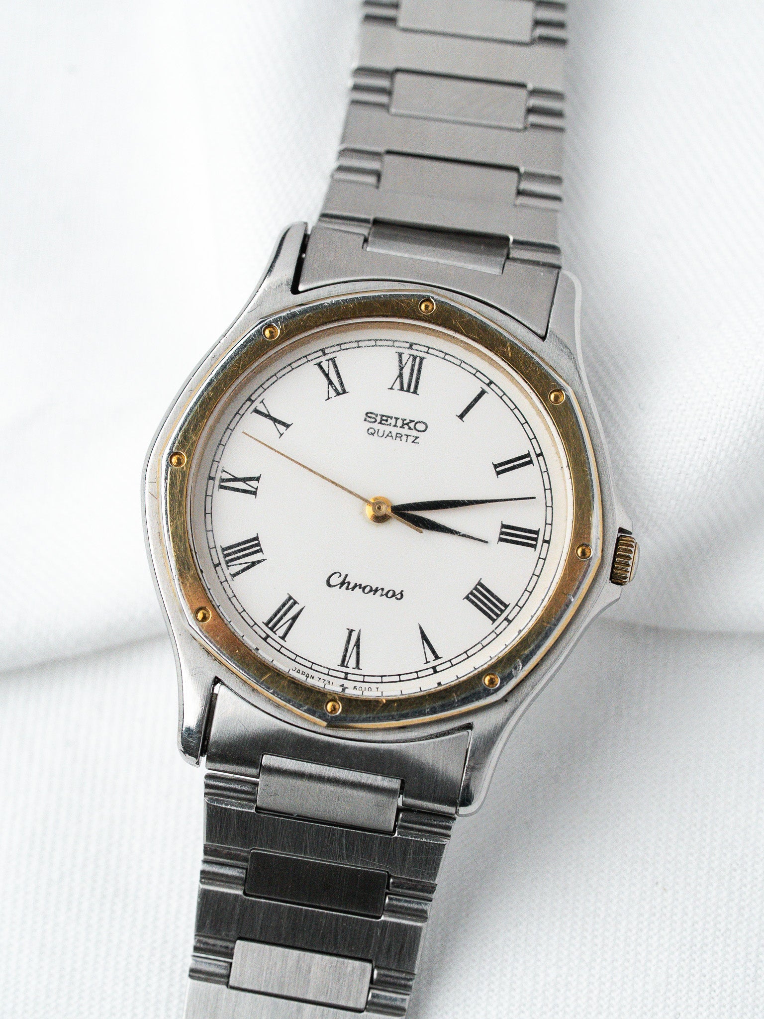 Seiko Chronos vintage quartz watch with white dial, Roman numerals, and two-tone steel bracelet