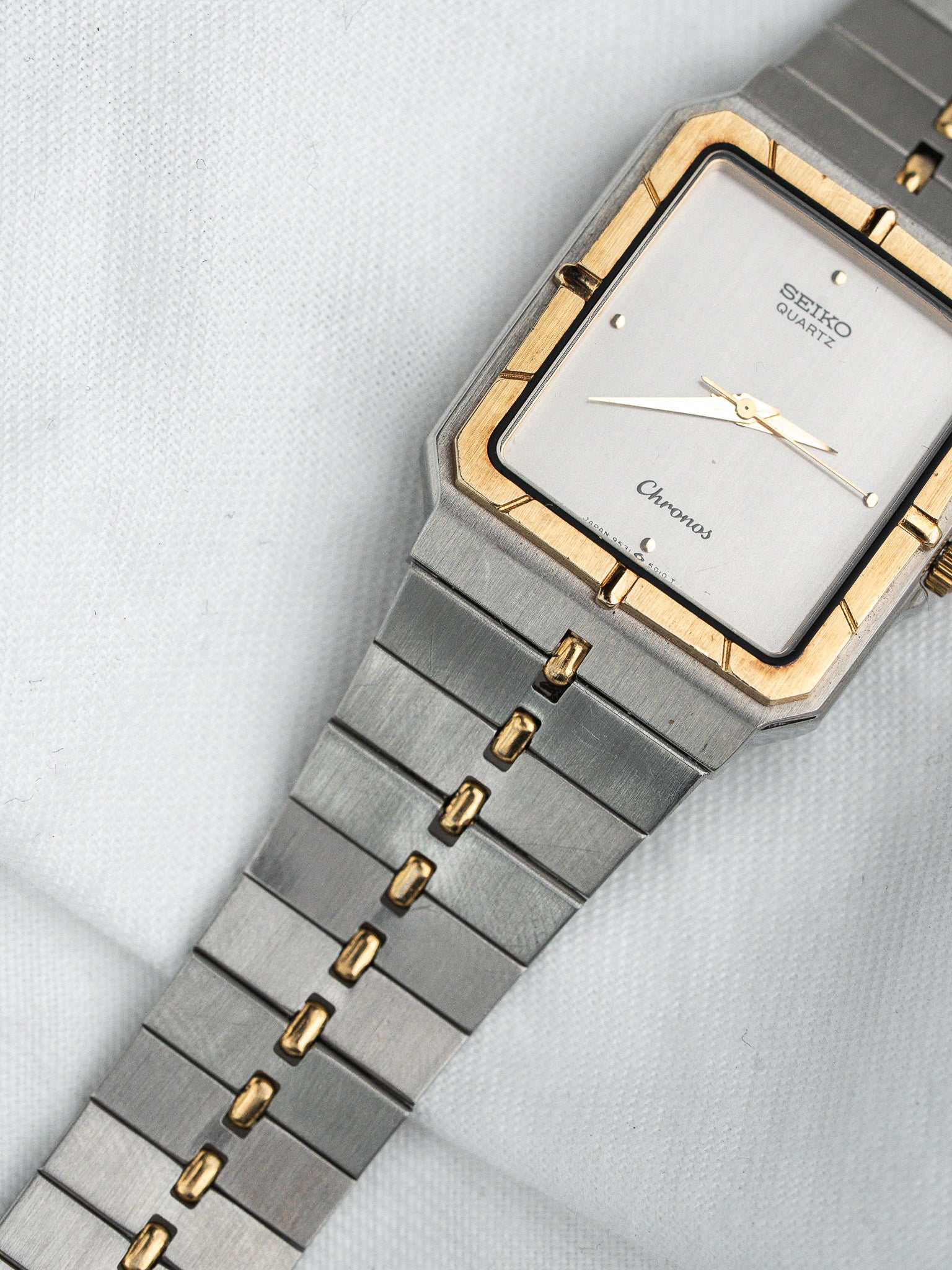 Seiko Chronos vintage watch with gold accents and silver bracelet on white background