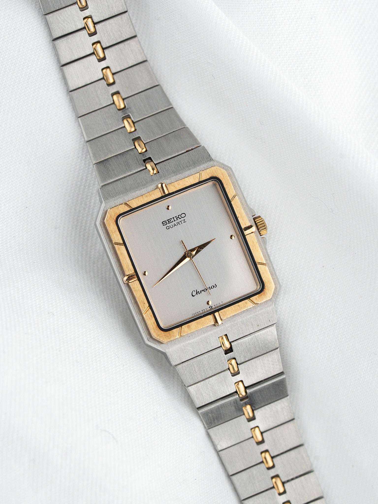 Seiko Chronos vintage quartz watch with silver dial, gold accents, and two-tone bracelet on white background