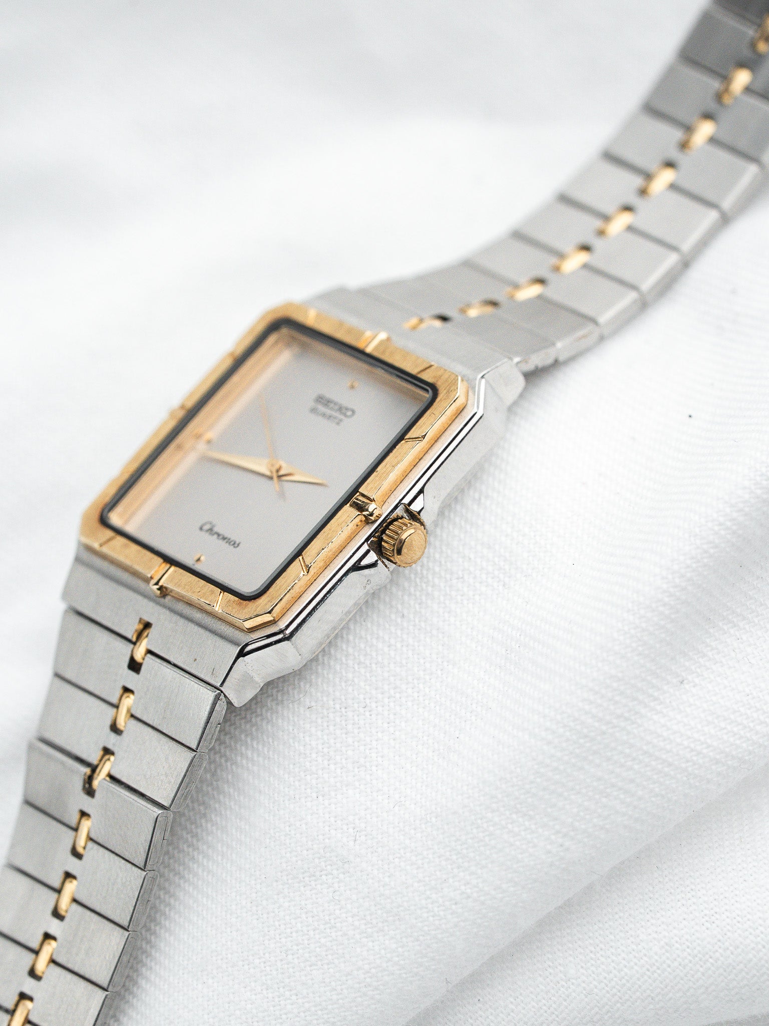 Seiko Chronos vintage watch with gold and steel case, silver dial, on white fabric