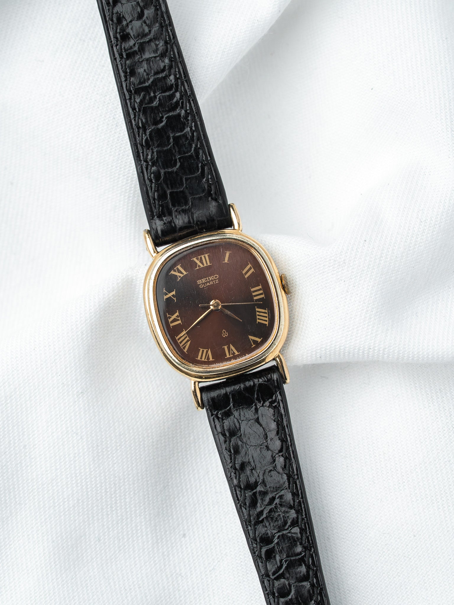 Seiko Quartz vintage watch with gold case, brown dial, Roman numerals, black crocodile strap