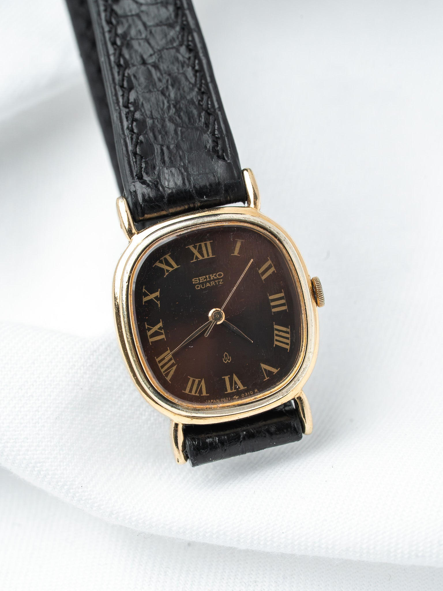 Seiko Quartz vintage watch with gold case, brown dial, Roman numerals, black leather strap